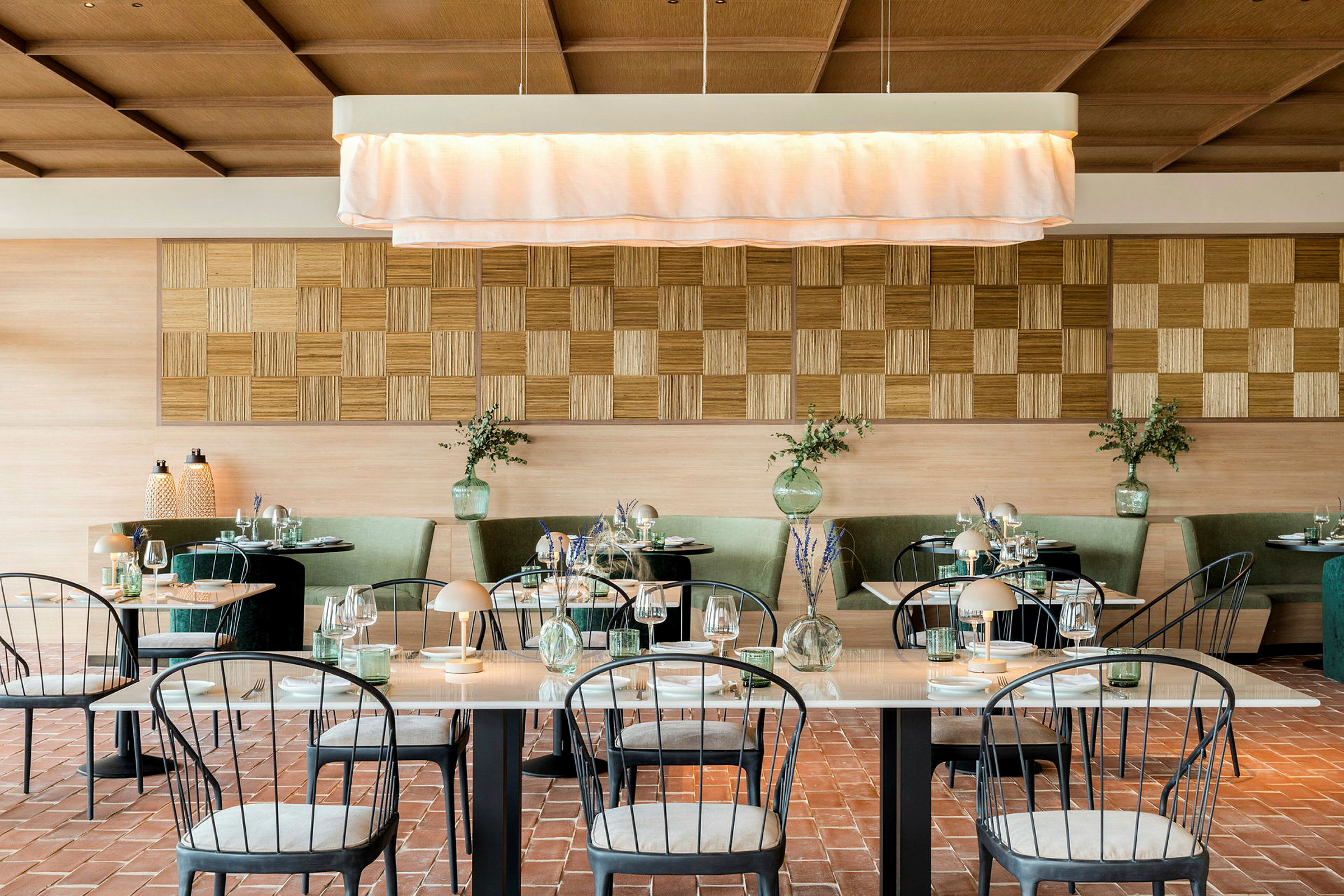 En elegant restaurang med väl dukade bord, gröna soffor och en ljus inredning. (AI-genererad text)