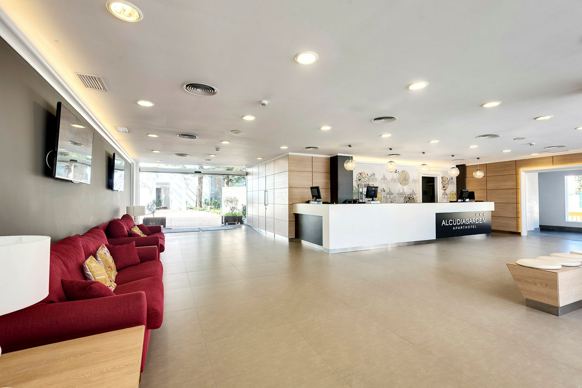 Hotellreception med en vit diskmottagning, röda soffor och modern inredning. (AI-genererad text)