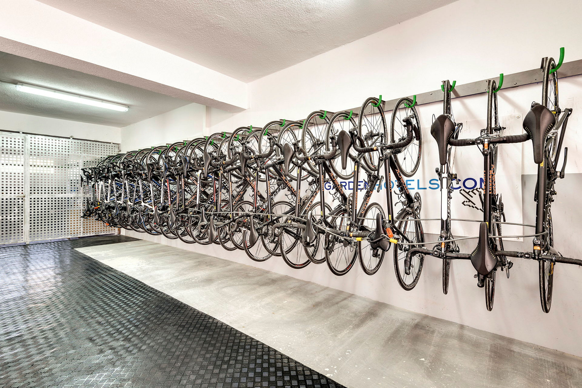En rad cyklar hängande på väggen i ett rum med hårda golv och vita väggar. (AI-genererad text)