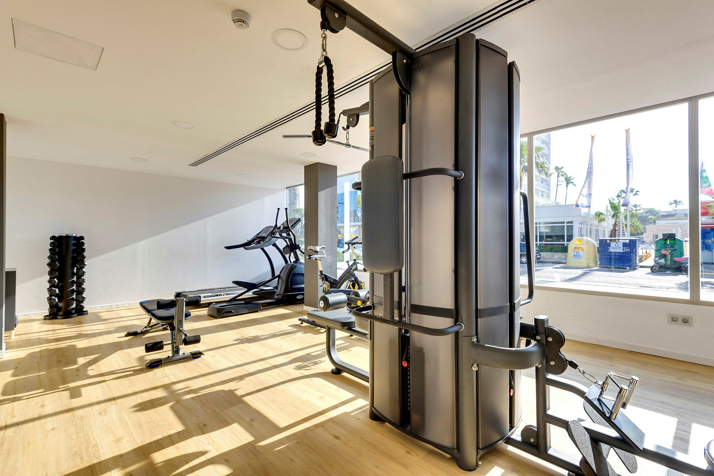 Gym med träningsutrustning och stora fönster. (AI-genererad text)