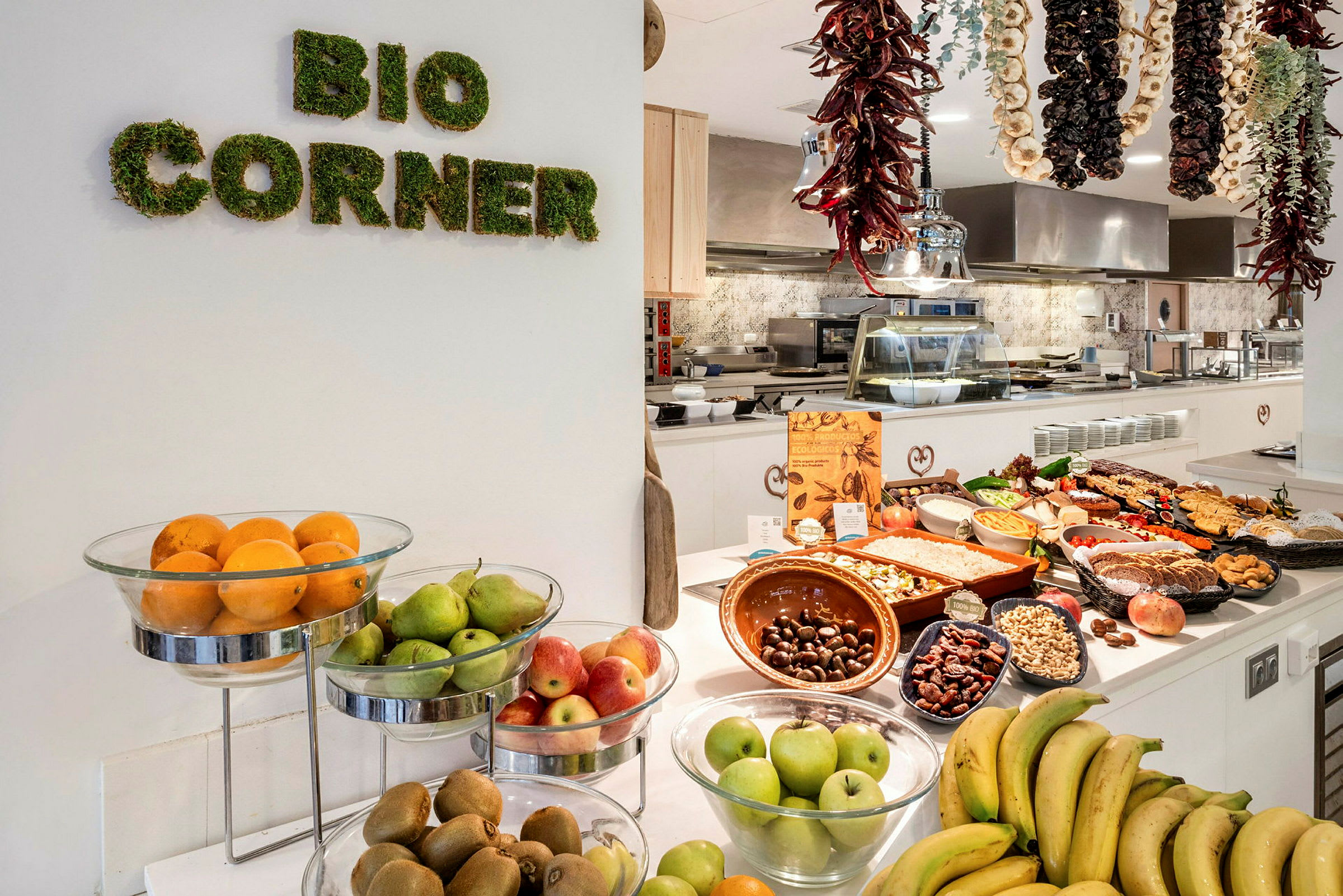 Frukt och matvaror på ett bord i ett köksområde med skylten 'Bio Corner'. (AI-genererad text)