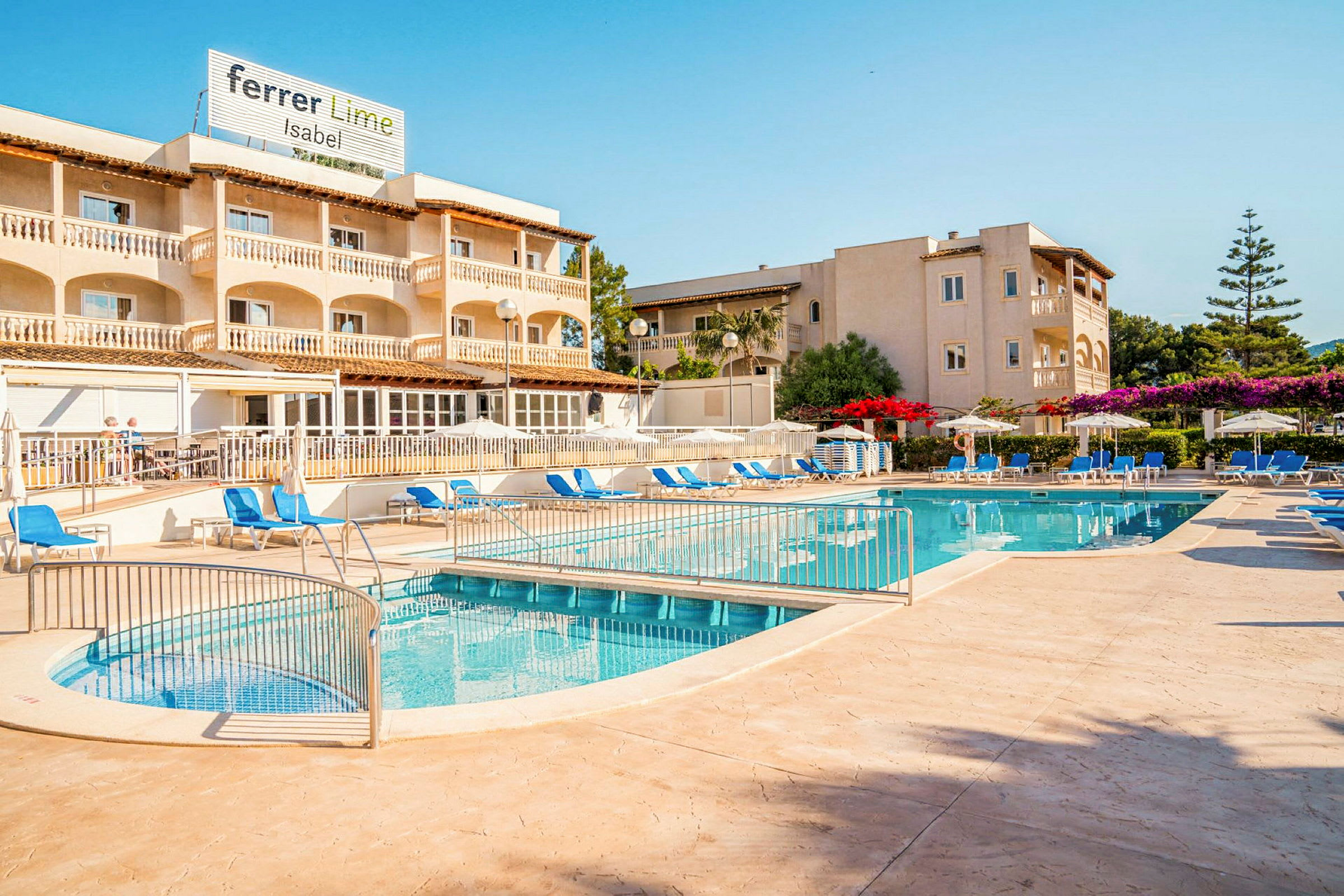 En utomhuspool med solstolar och parasoller framför ett hotell. (AI-genererad text)