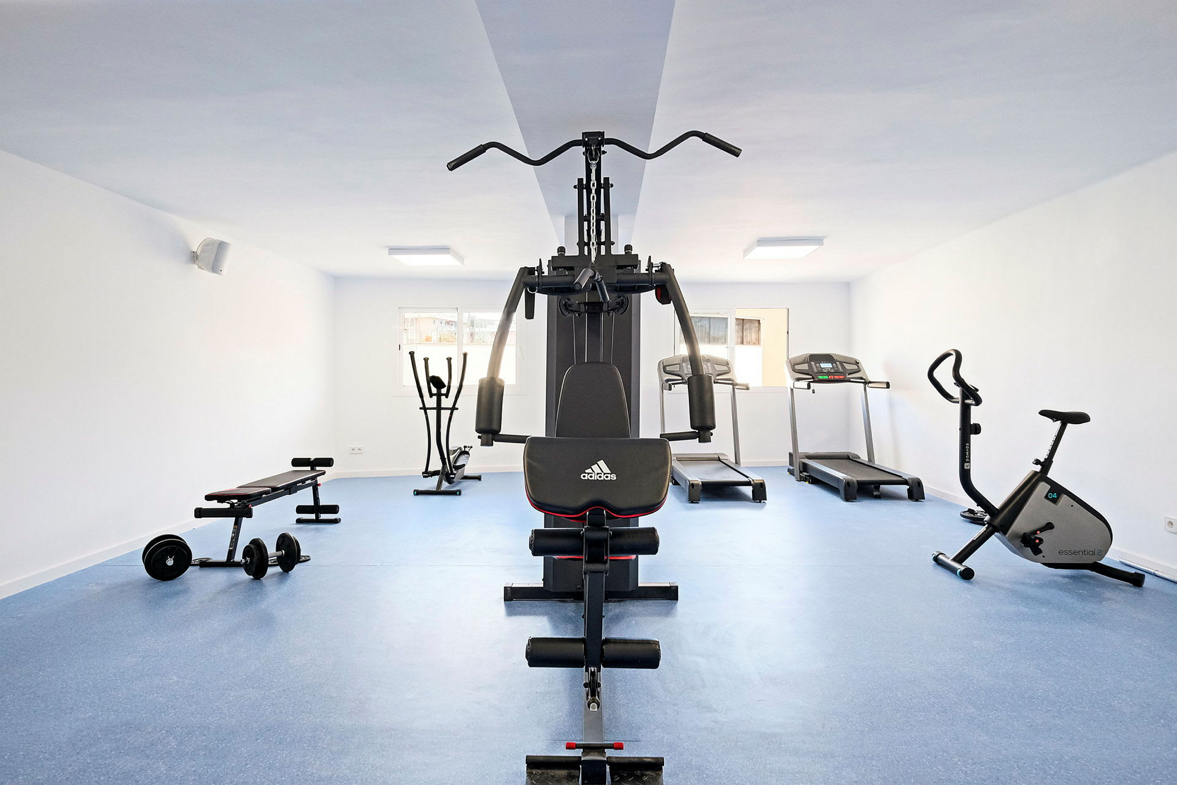 Ett gym med träningsmaskiner, inklusive löpband, träningscykel och multigym. (AI-genererad text)