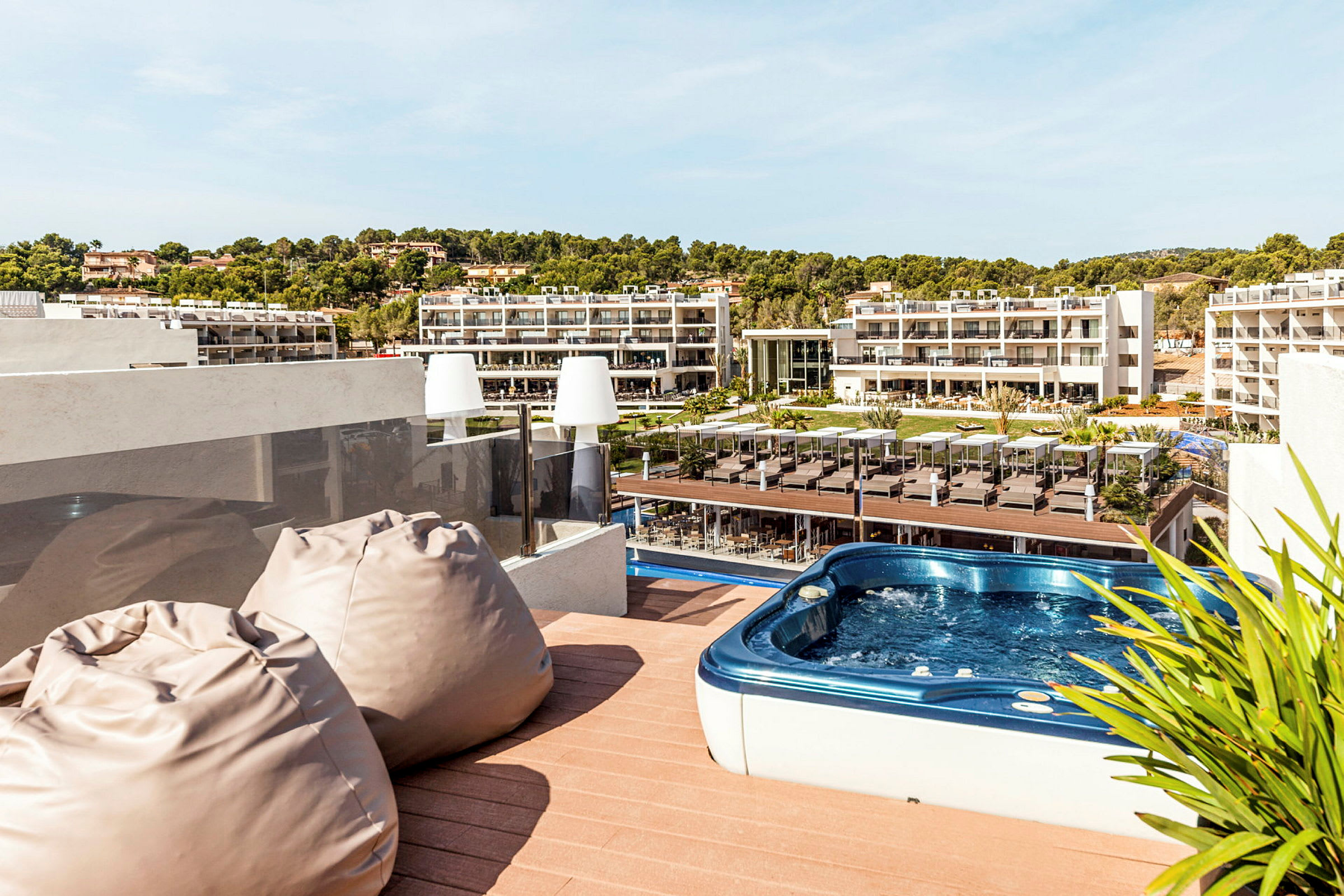 Terrass med bubbelpool och utsikt över hotellområde. (AI-genererad text)