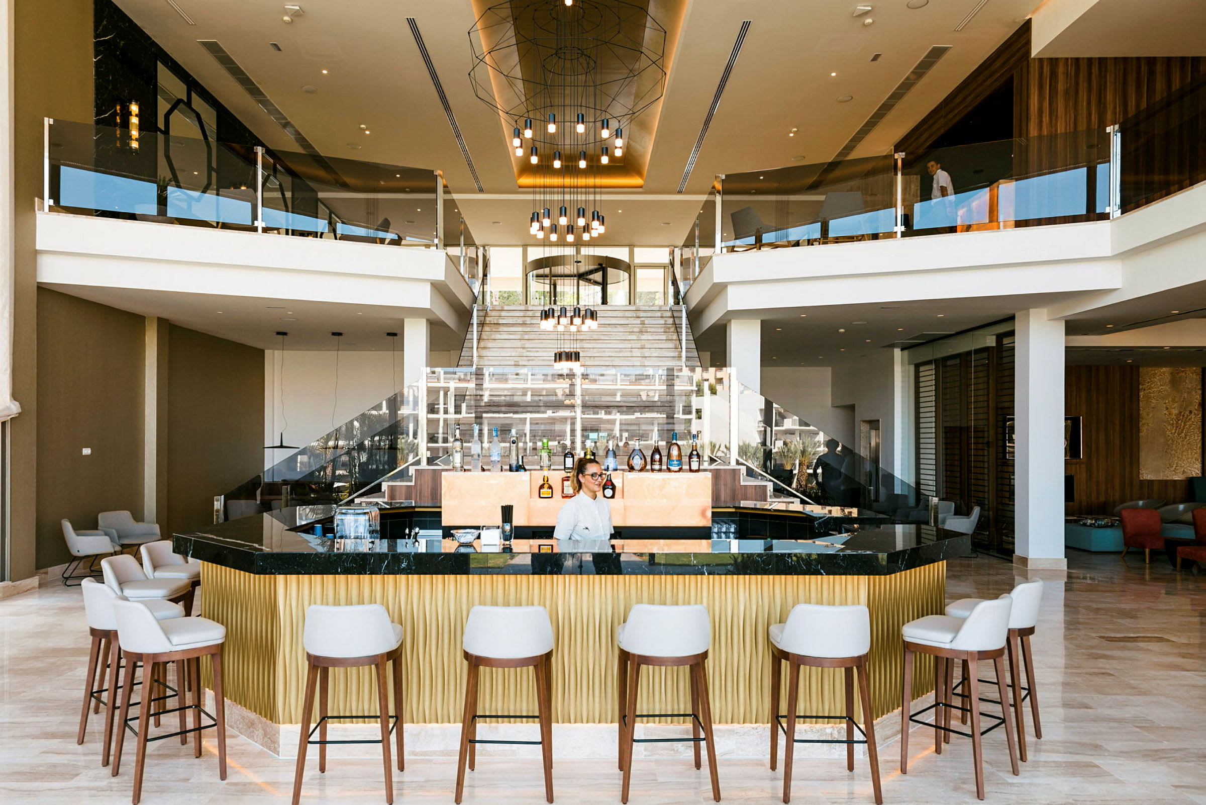 En hotellfoajé med en modern bar, sittplatser och en central trappa. (AI-genererad text)