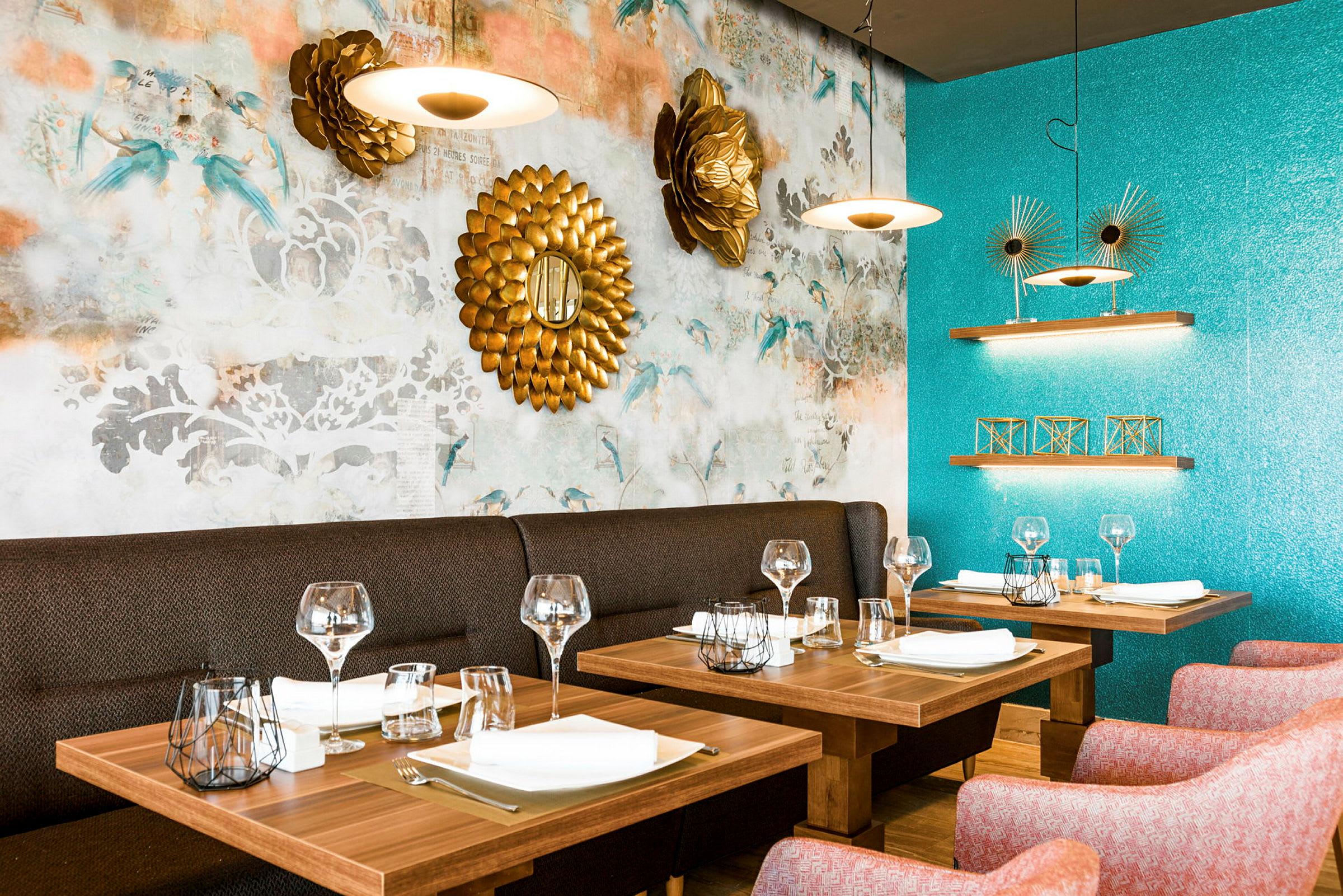 Interiör av en restaurang med dukade träbord och dekorativa föremål på turkosa och mönstrade väggar. (AI-genererad text)