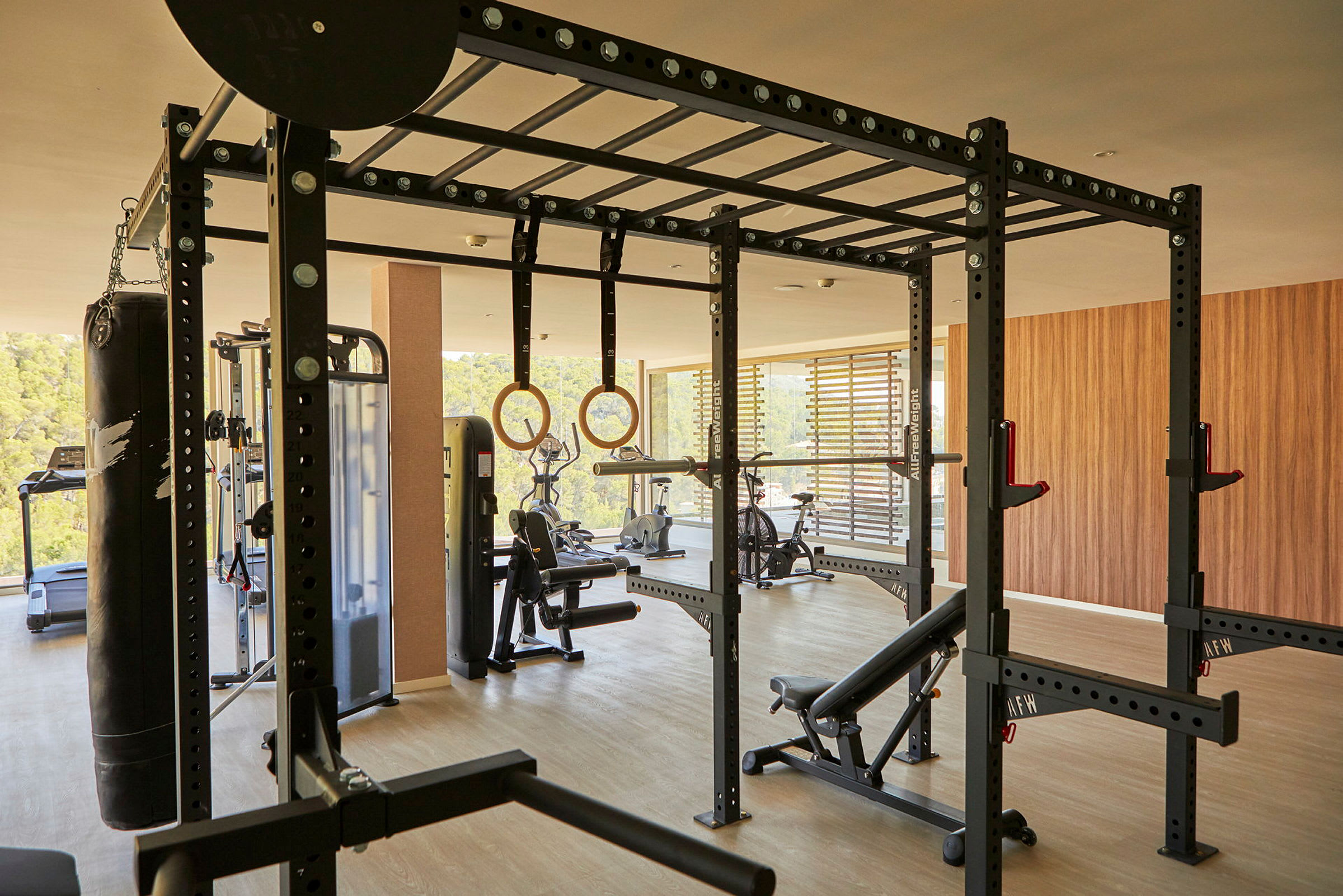 Ett modernt gym med olika träningsredskap som tyngdställ, träningscyklar och romerska ringar. (AI-genererad text)