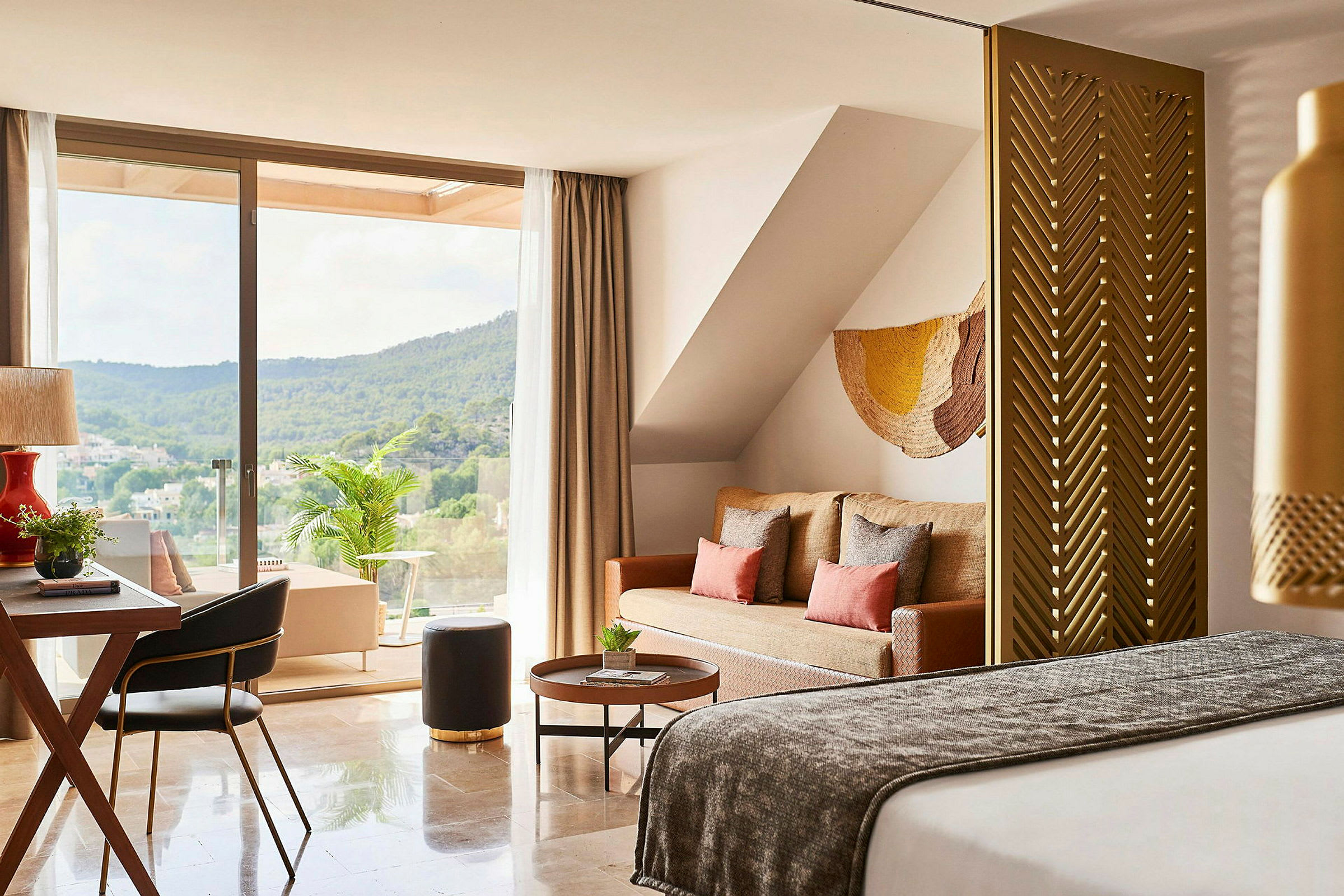 Ett modernt hotellrum med sittgrupp och en terrass med utsikt över grönskande landskap. (AI-genererad text)