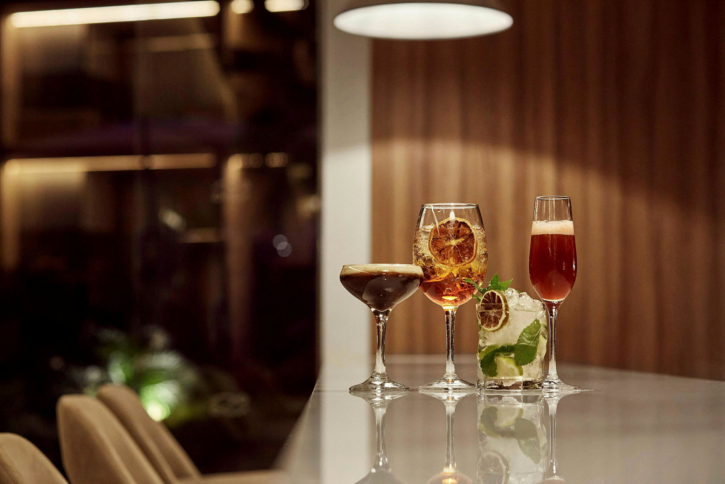 Fyra cocktails på ett bord i en elegant miljö. (AI-genererad text)