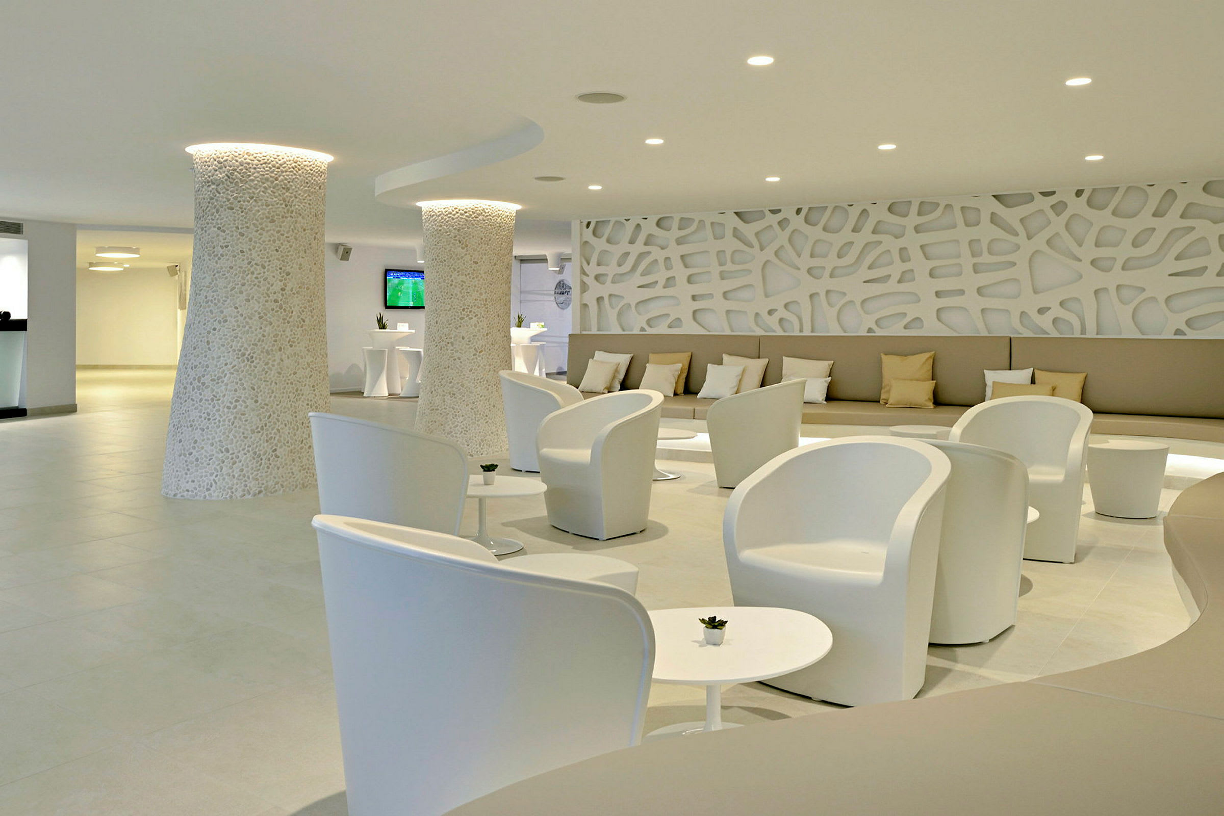 En modern hotellobby med vita stolar, små bord och dekorativa väggar. (AI-genererad text)