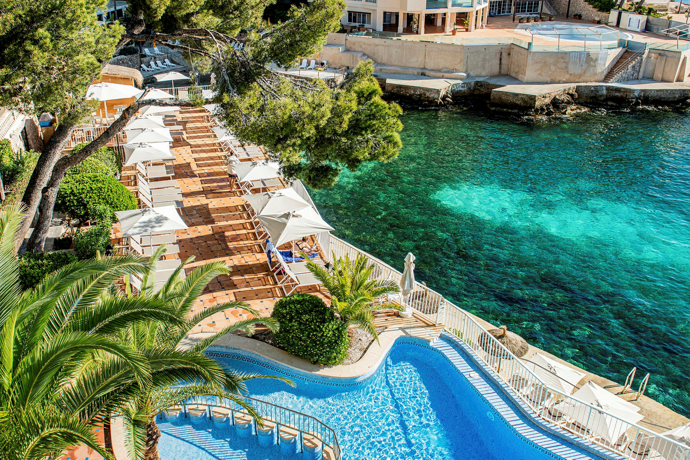 Utomhuspool och solstolar vid havet. (AI-genererad text)