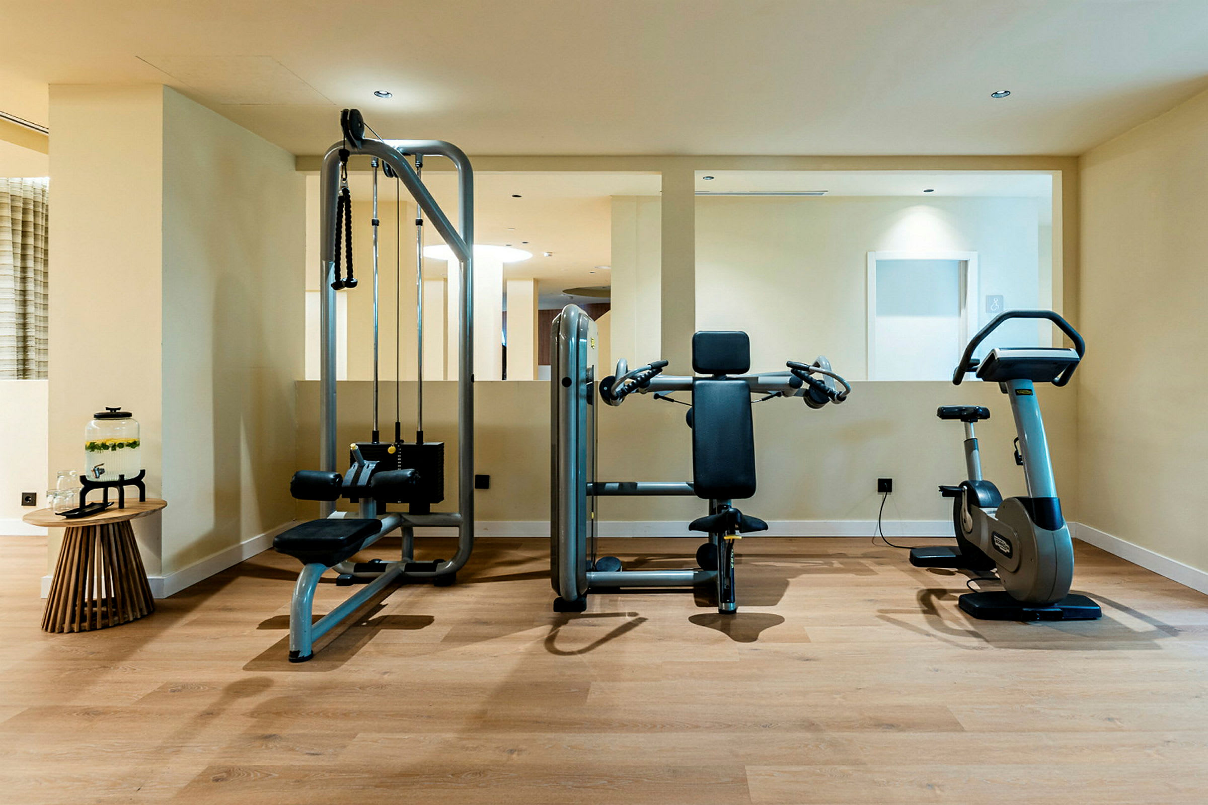Rum med träningsutrustning, inklusive multigym och motionscykel. (AI-genererad text)