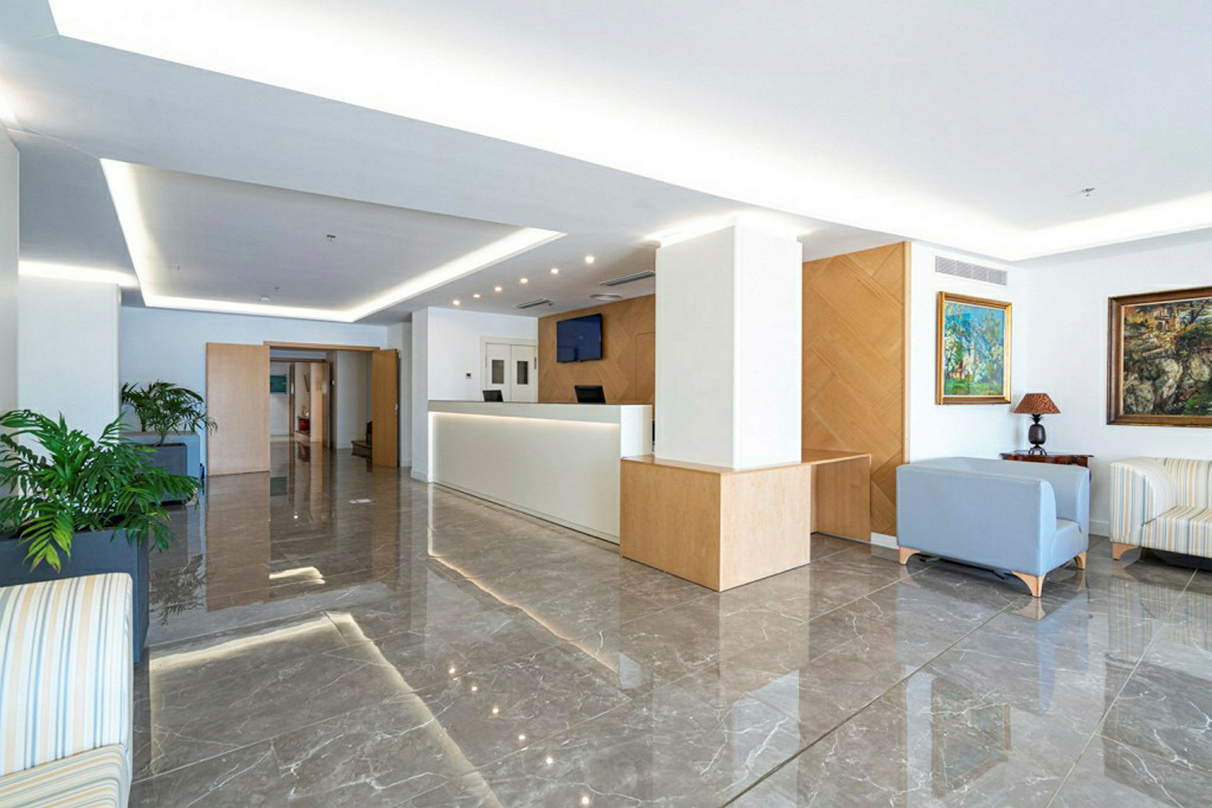 Ett modernt och ljust hotelläge med en reception och sittgrupp. (AI-genererad text)