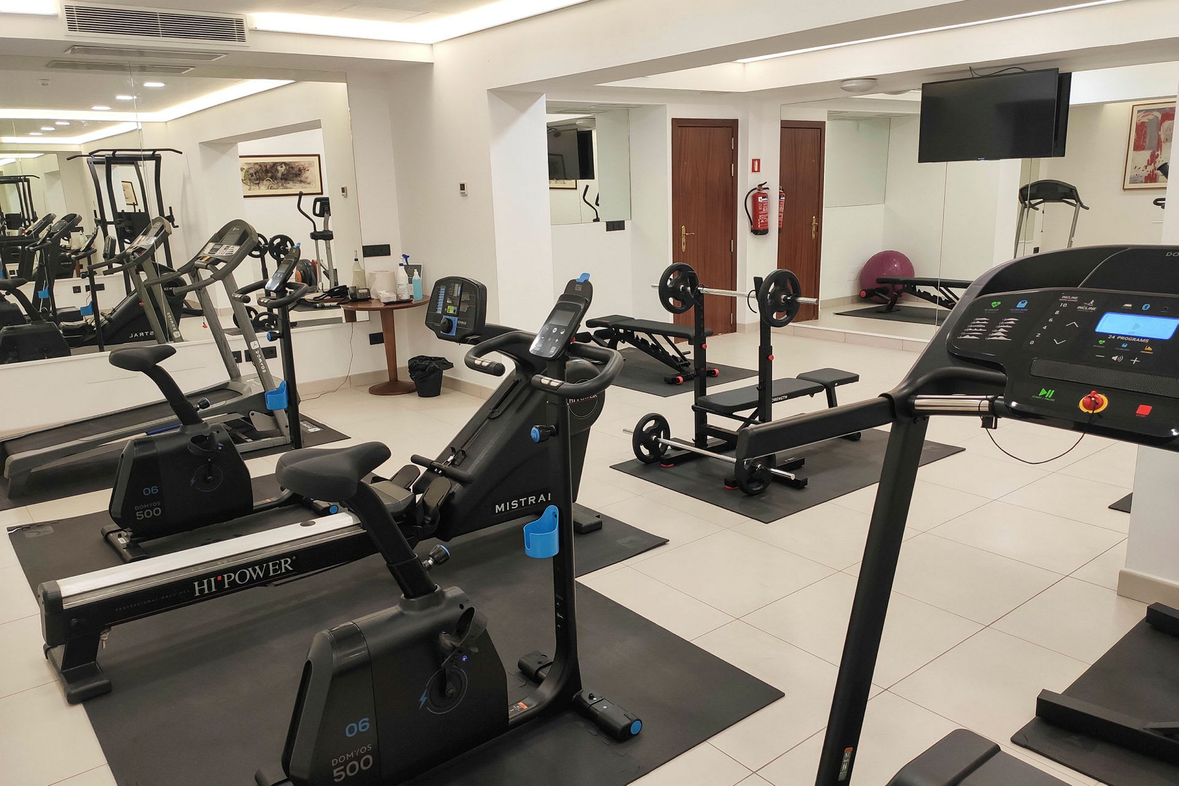 Bild av ett gym med moderna träningsmaskiner, inklusive löpband, motionscyklar och utrustning för styrketräning. (AI-genererad text)