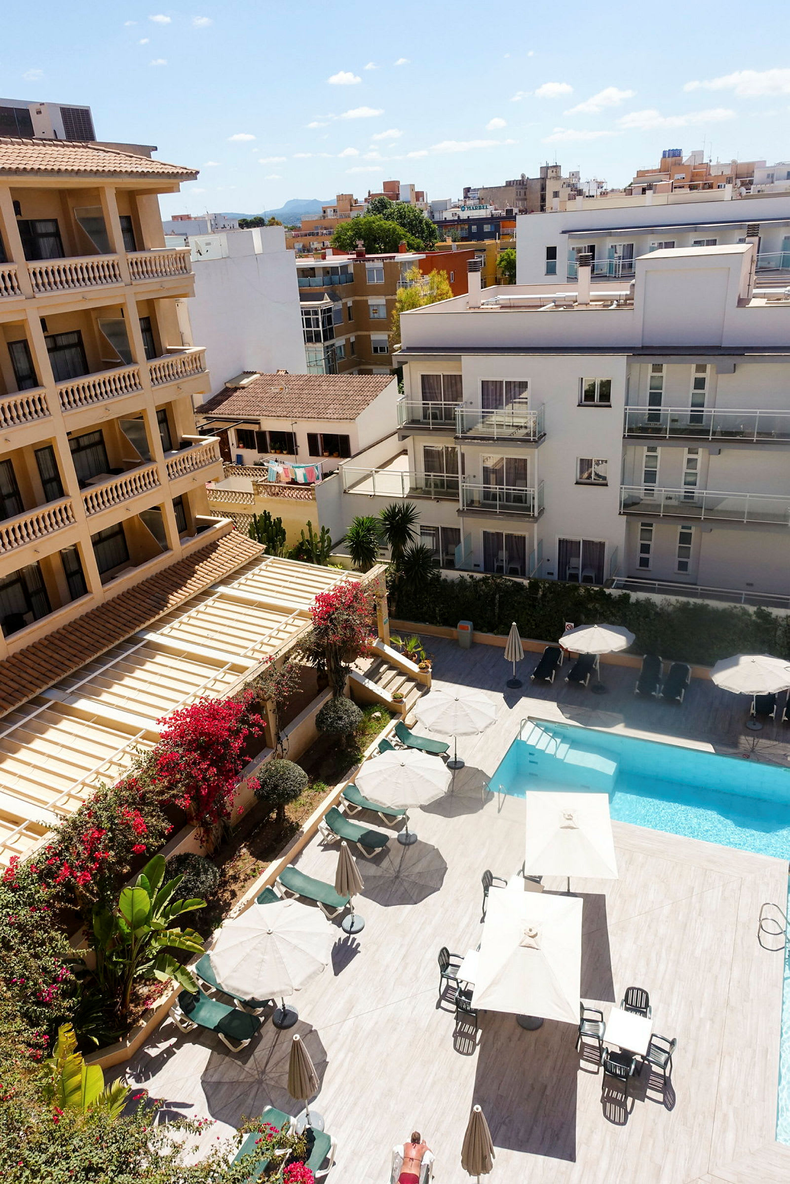 Bild av hotellområde med pool, solstolar och parasoller. (AI-genererad text)