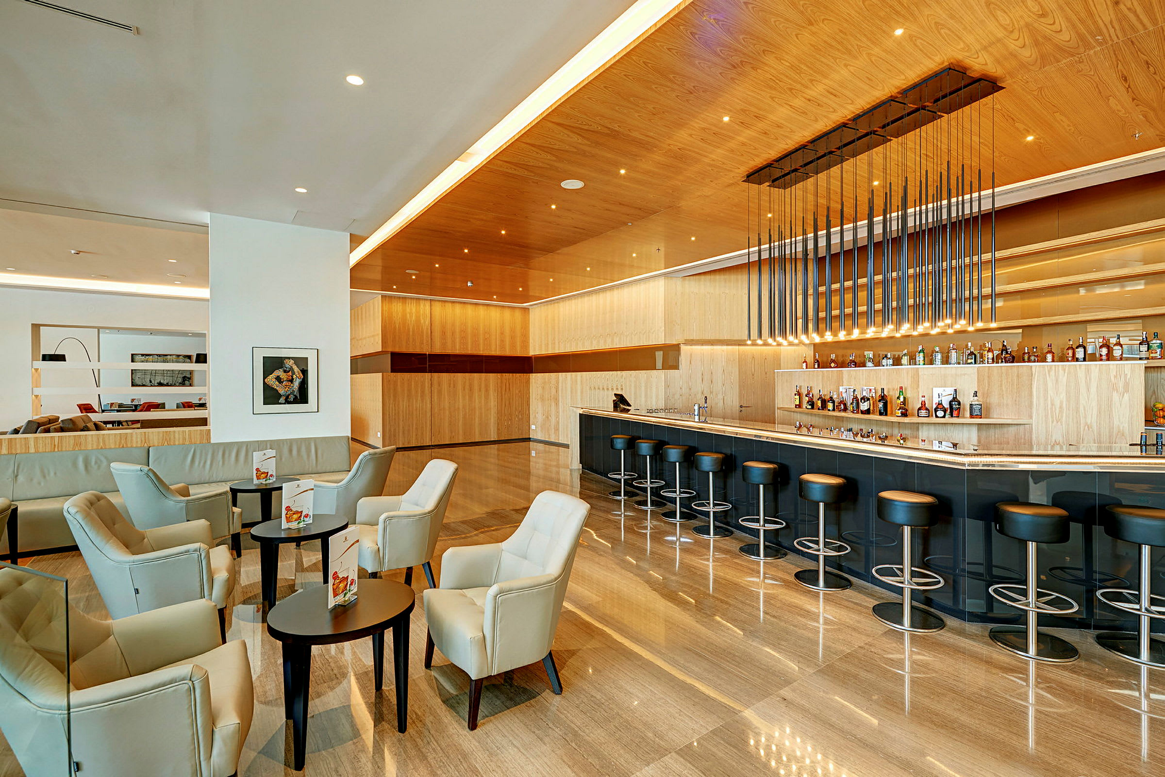 Modern hotellbar med sittgrupper och högstolar vid bardisken. (AI-genererad text)