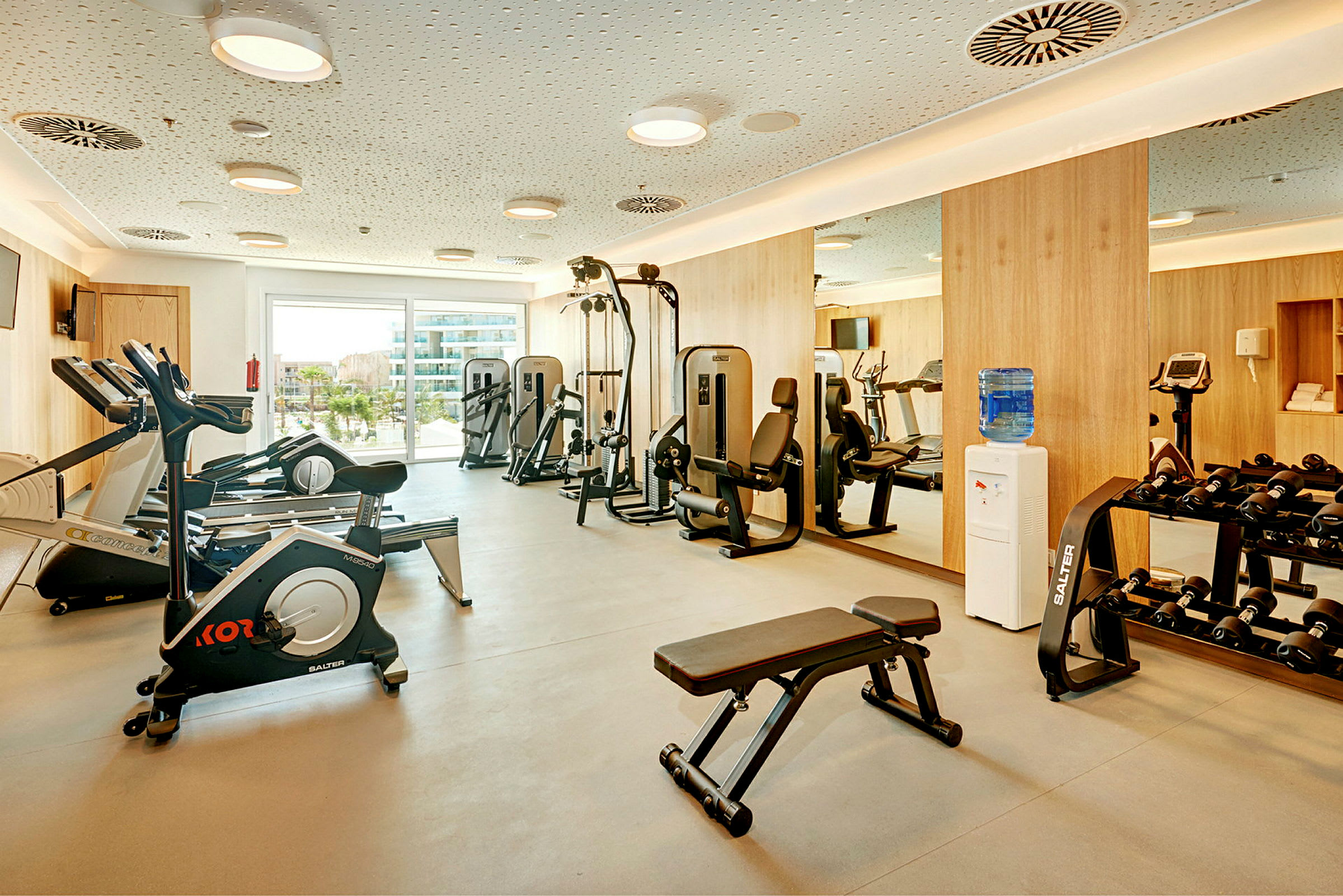 Ett gym med träningsutrustning, inklusive löpband, styrketräningsmaskiner och hantlar. (AI-genererad text)