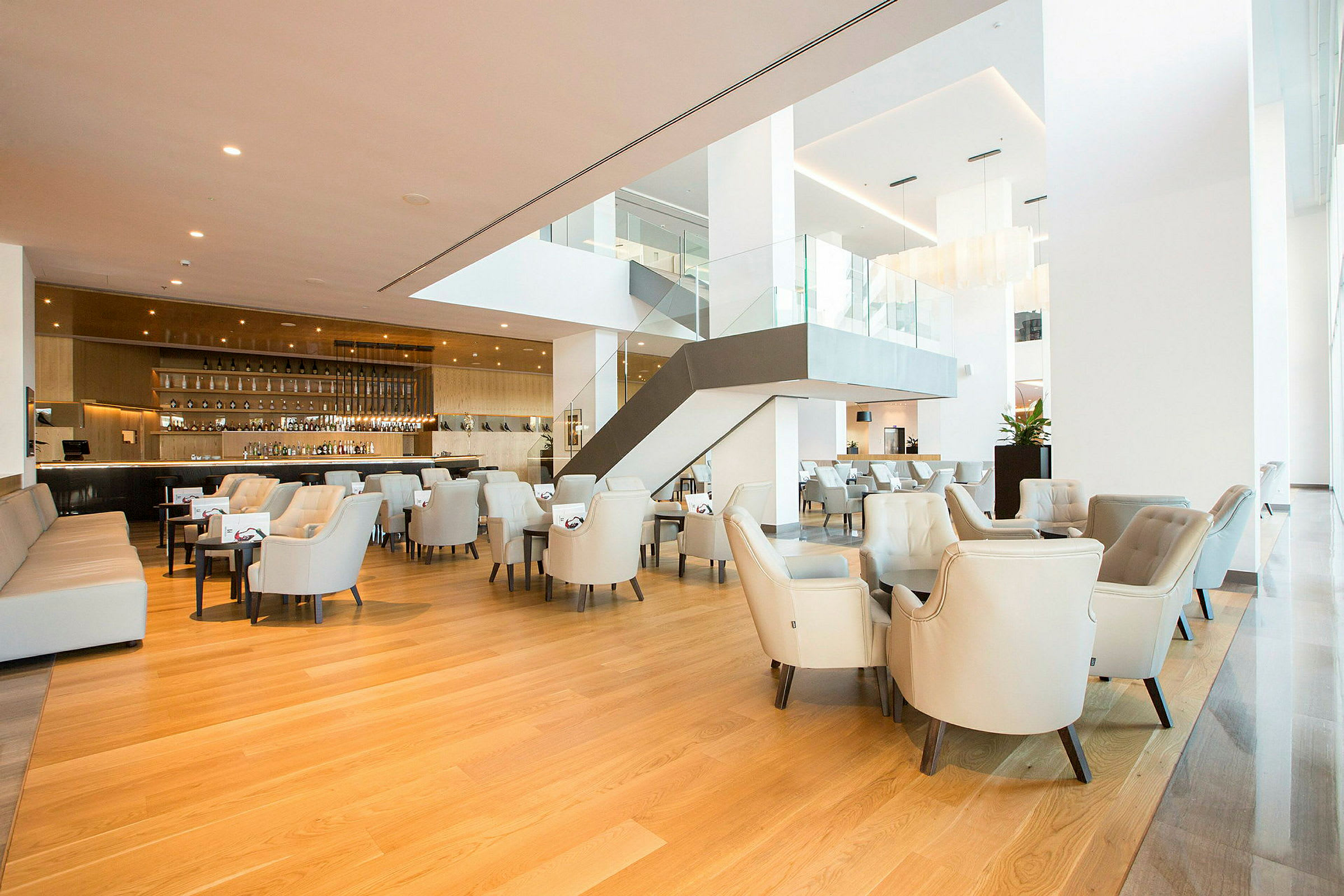 Modern lobby med ljusa sittmöbler, trämöbler och en trappa. (AI-genererad text)