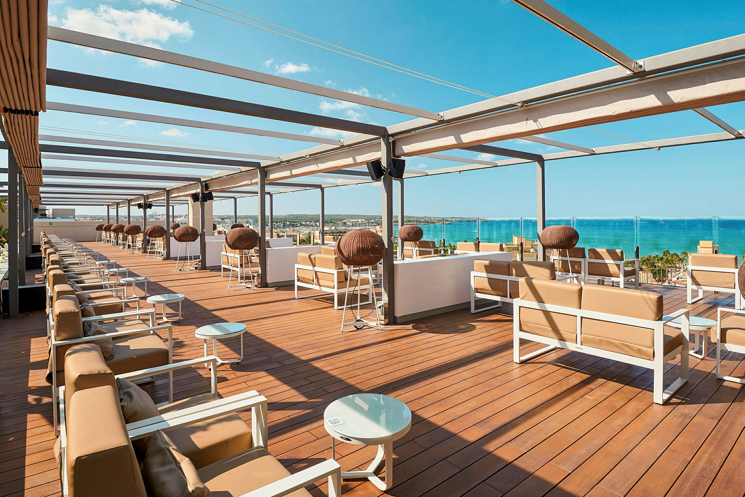 En takterrass med sittgrupper och utsikt över havet. (AI-genererad text)