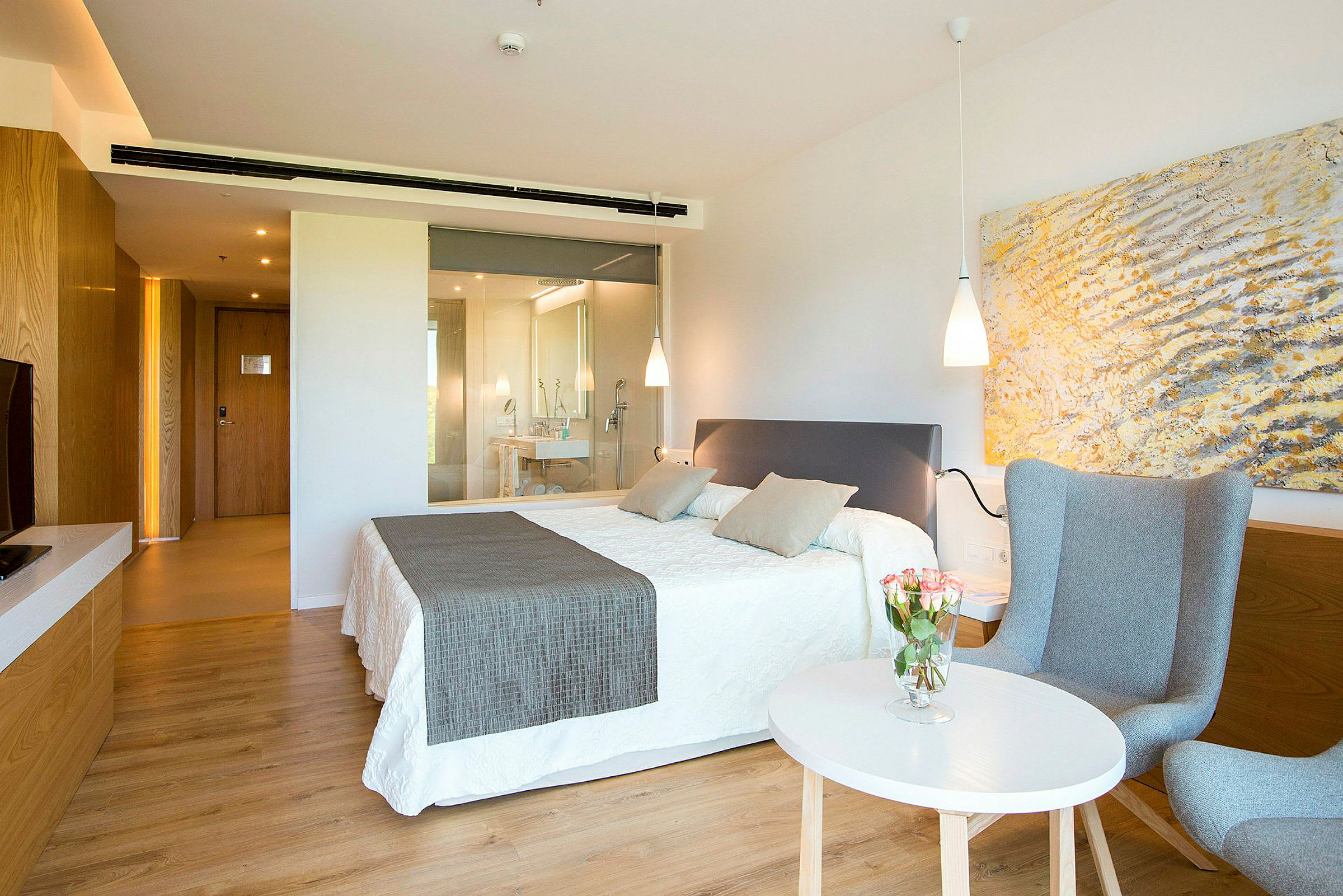 Ett modernt hotellrum med en dubbelsäng och en sittgrupp. (AI-genererad text)
