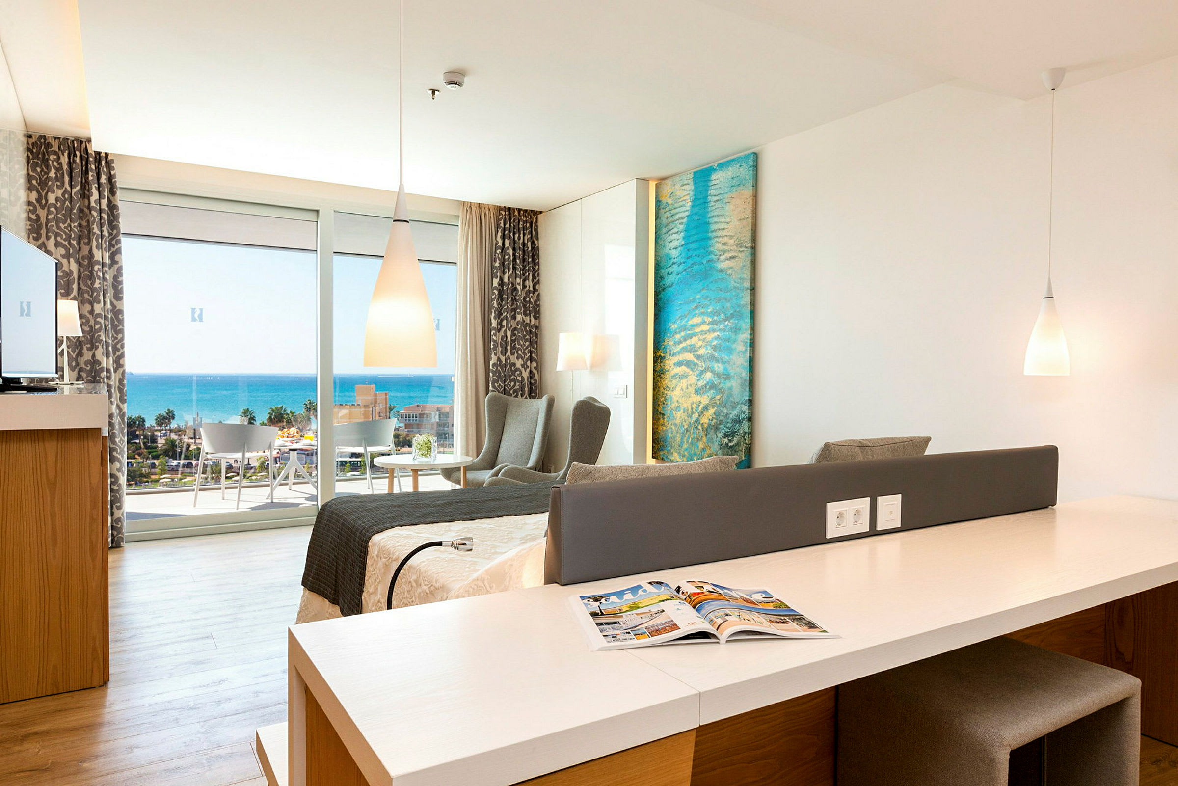 Ett hotellrum med modern inredning och utsikt över havet. (AI-genererad text)