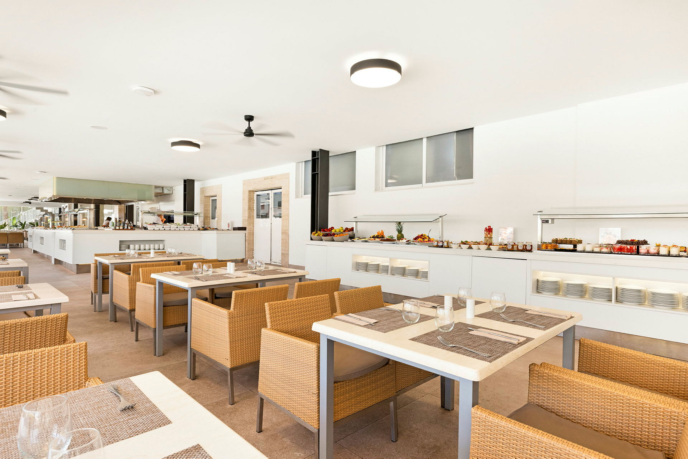 En restaurang med flera bord och korgstolar. (AI-genererad text)