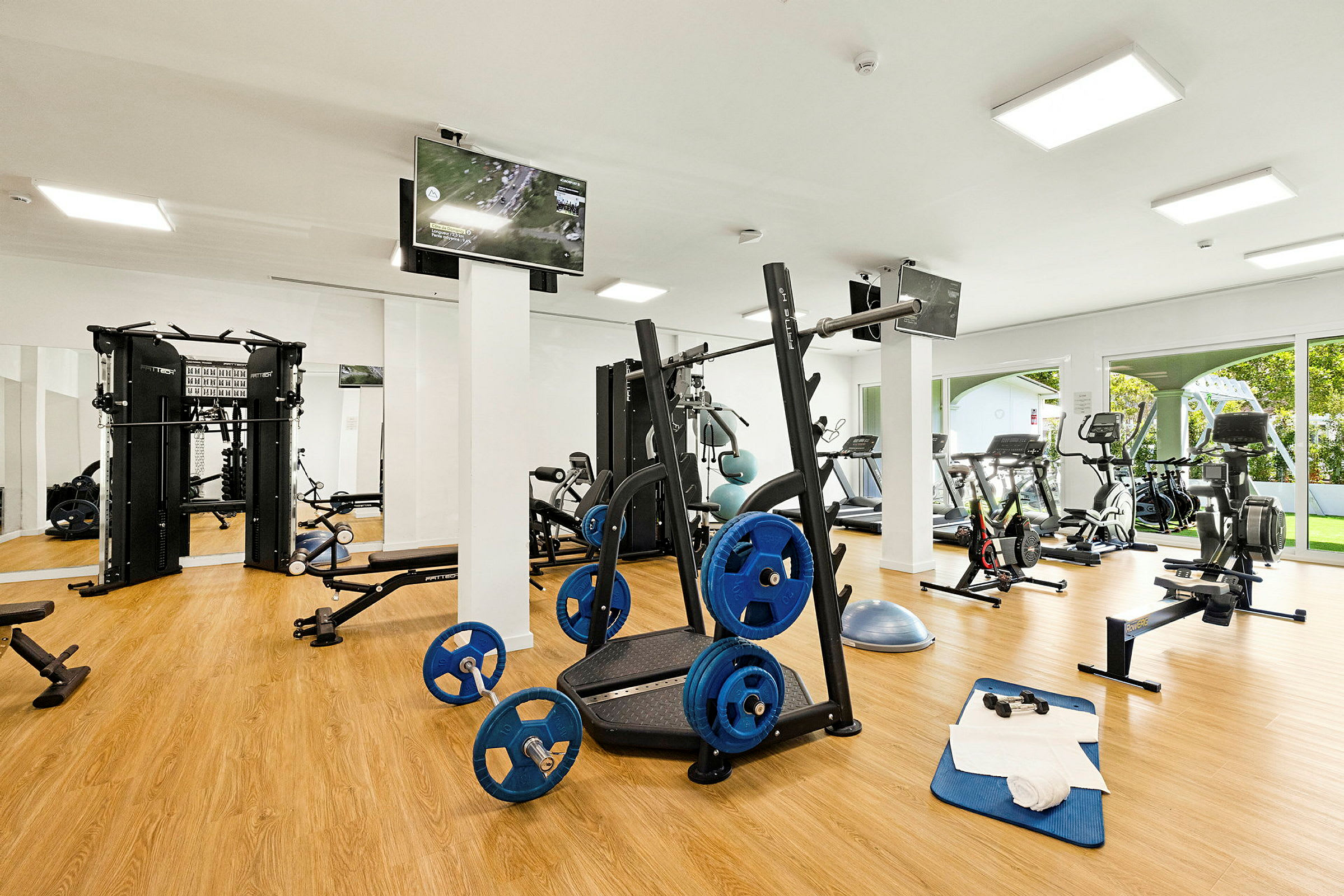 Ett gym med träningsutrustning såsom löpband, cyklar och viktställ. (AI-genererad text)