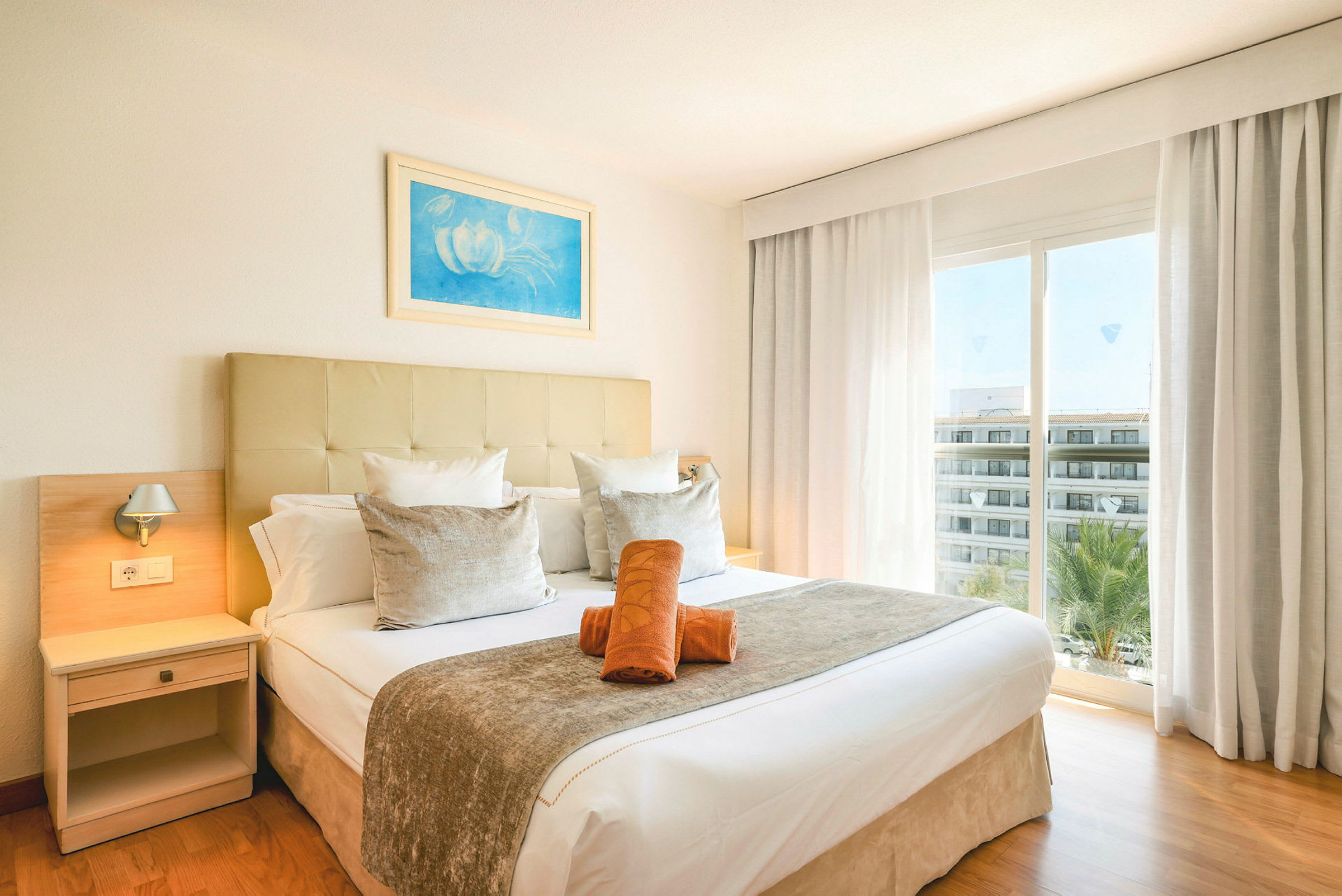 Hotellrum med en dubbelsäng samt fönster som vetter mot utsikten. (AI-genererad text)