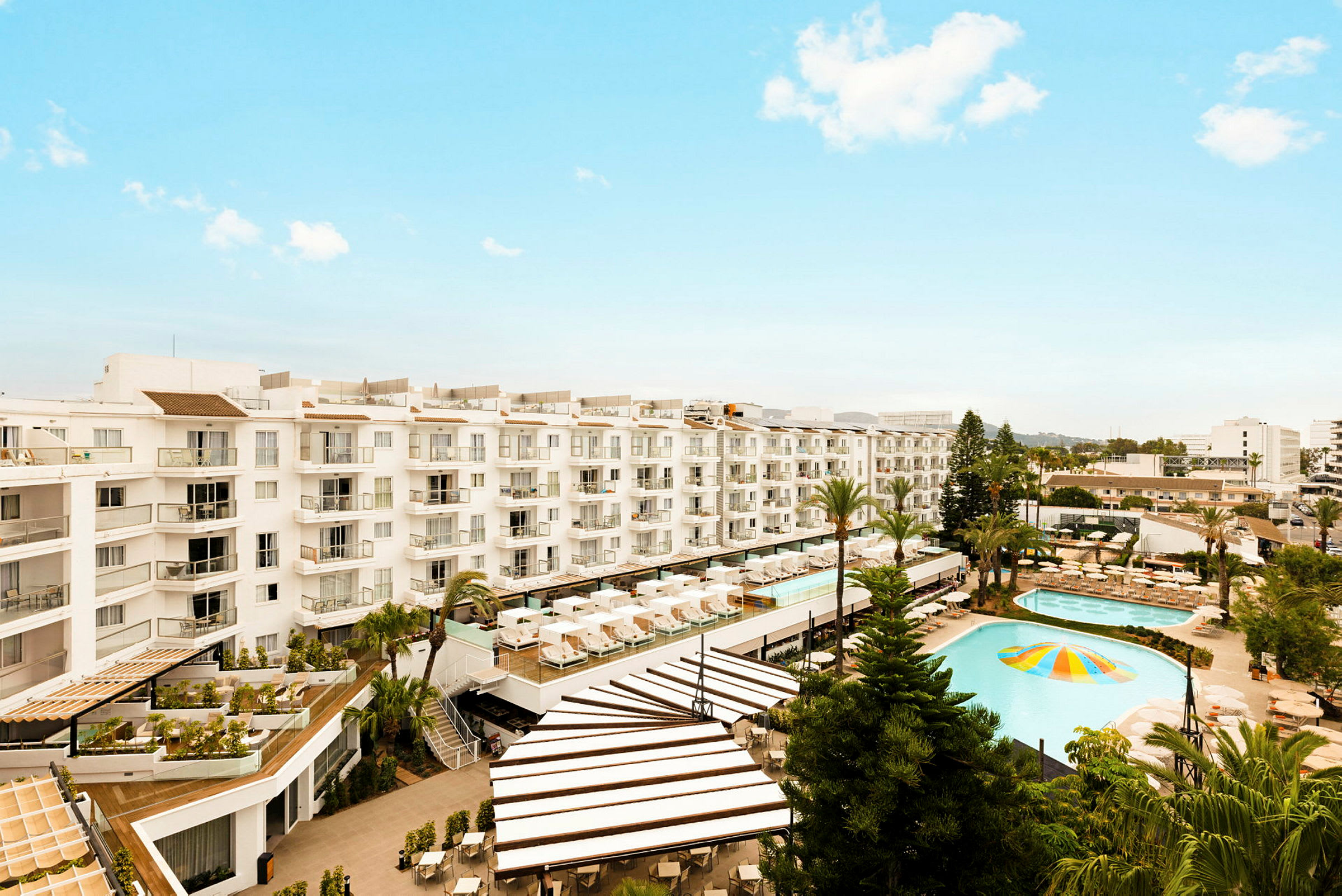 Bild av ett hotell med poolområde och solstolar. (AI-genererad text)
