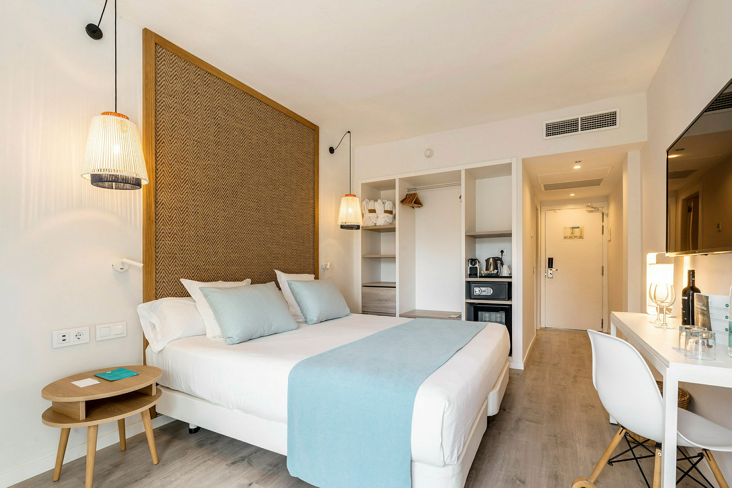 Hotellrum med säng, sittmöbler, tv och minibar. (AI-genererad text)