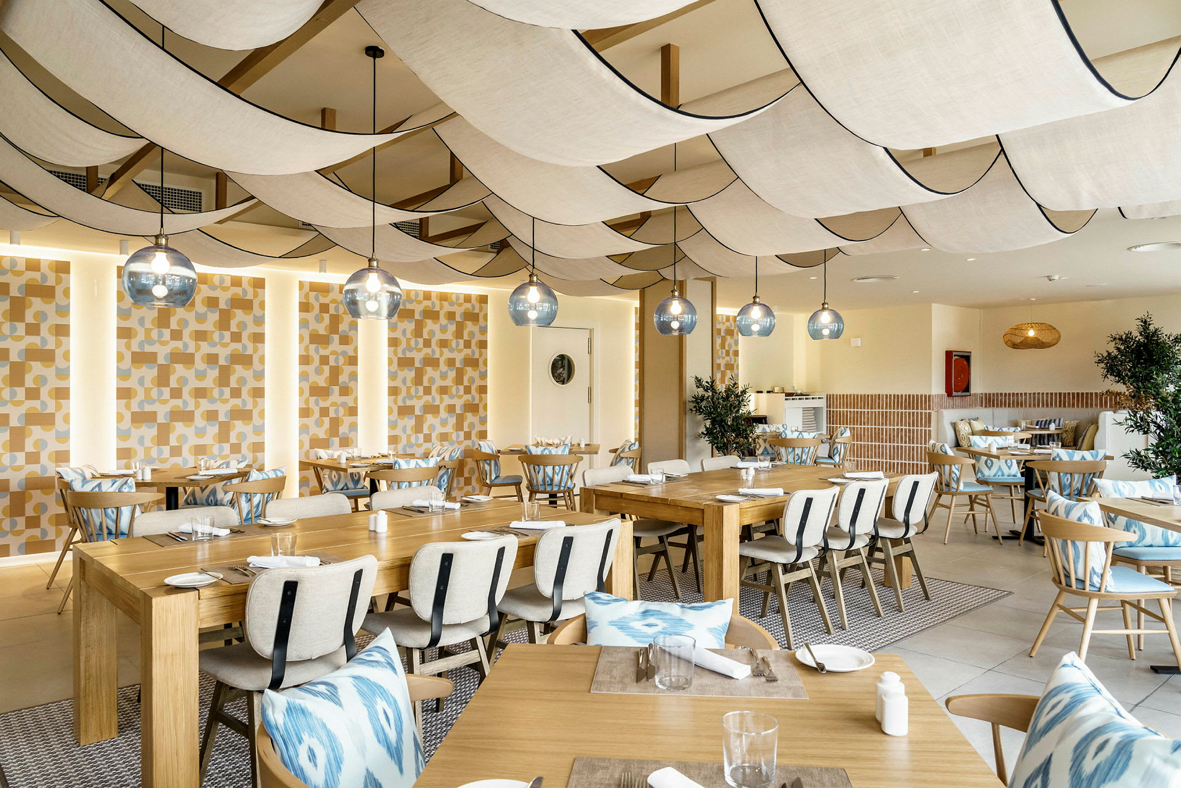 En restaurang med bord och stolar samt dekorerad inredning. (AI-genererad text)