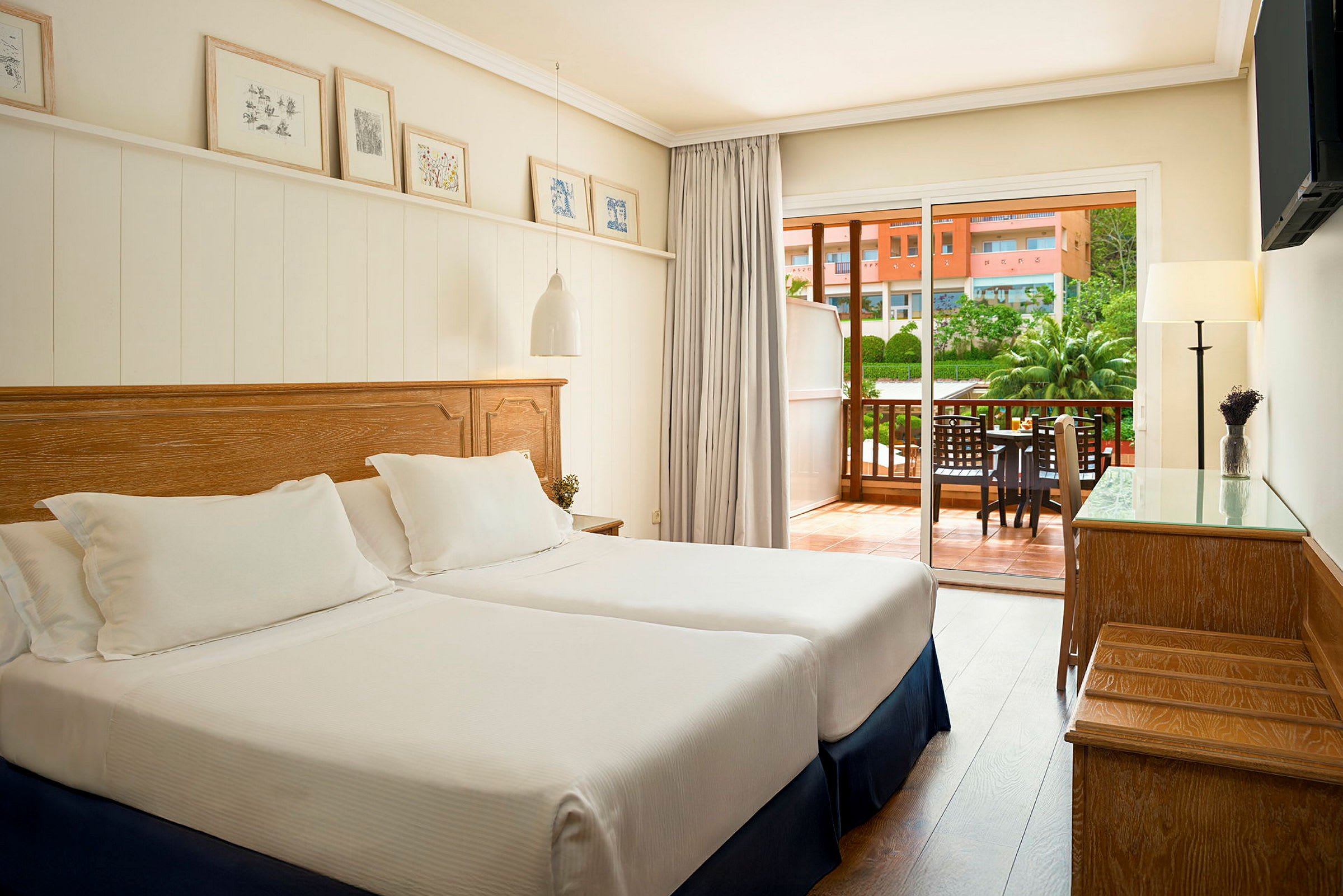 Ett hotellrum med två enkelsängar och en balkong utanför. (AI-genererad text)