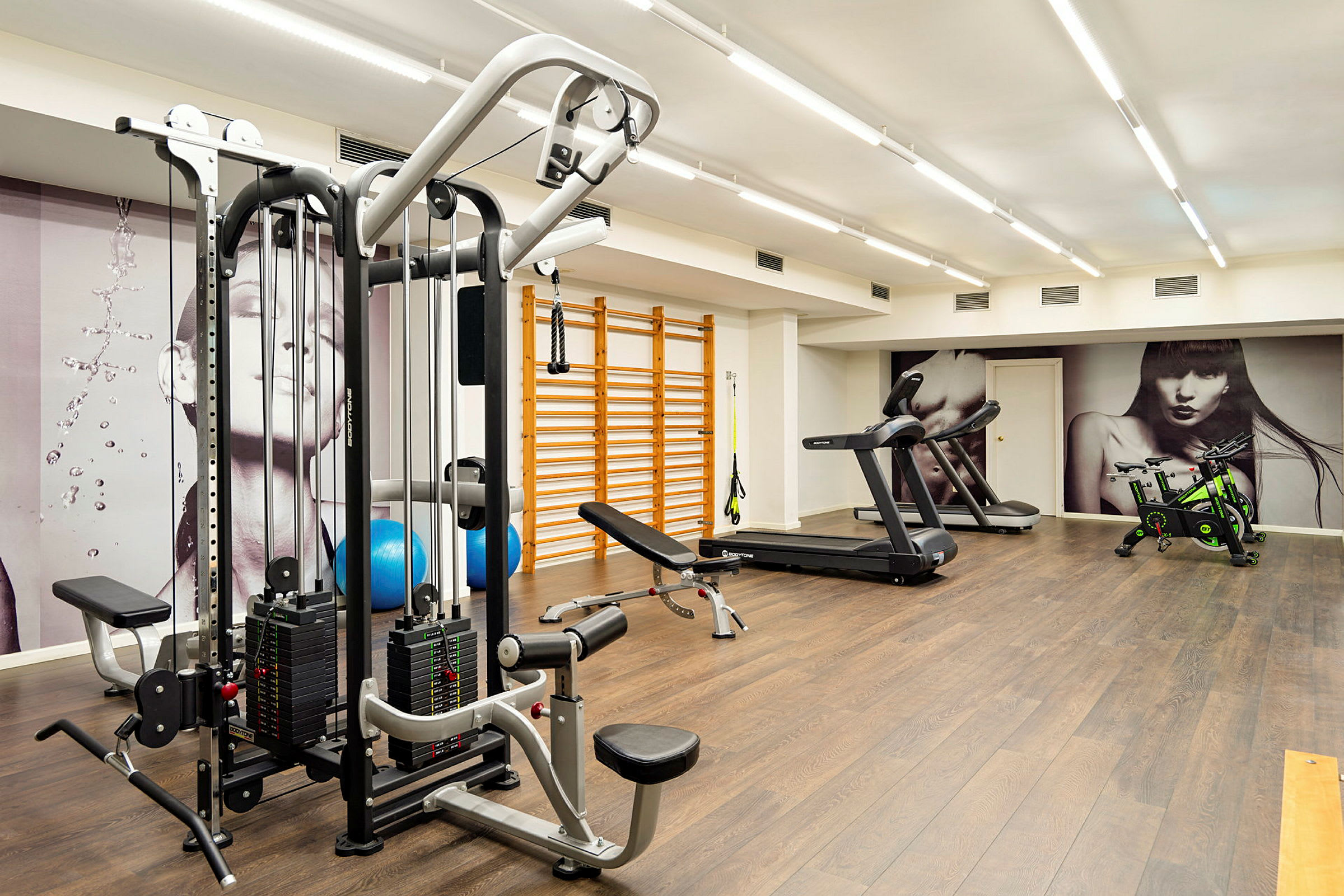 Ett gym med träningsmaskiner, löpband, spinncyklar och ribbstolar. (AI-genererad text)