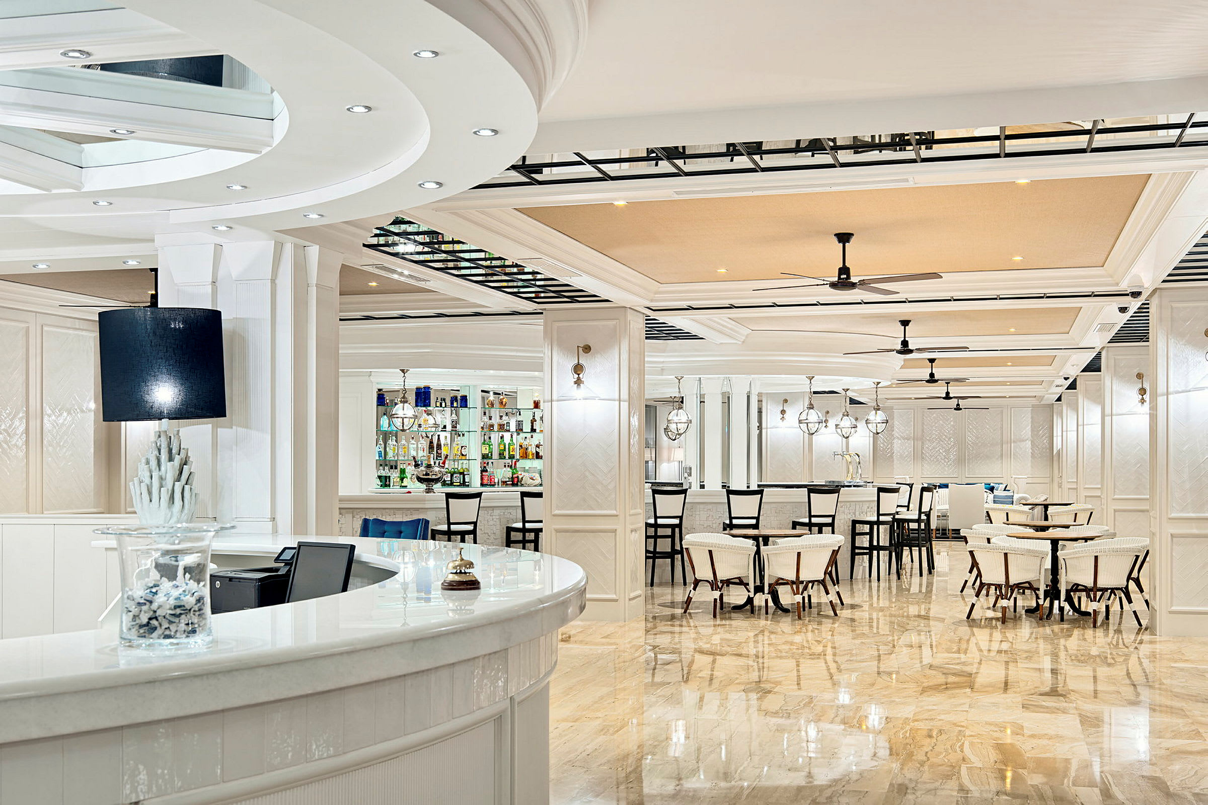 Bild föreställer en ljus och elegant bar och restaurangmiljö med vit interiör och spegelpolerade golv. (AI-genererad text)