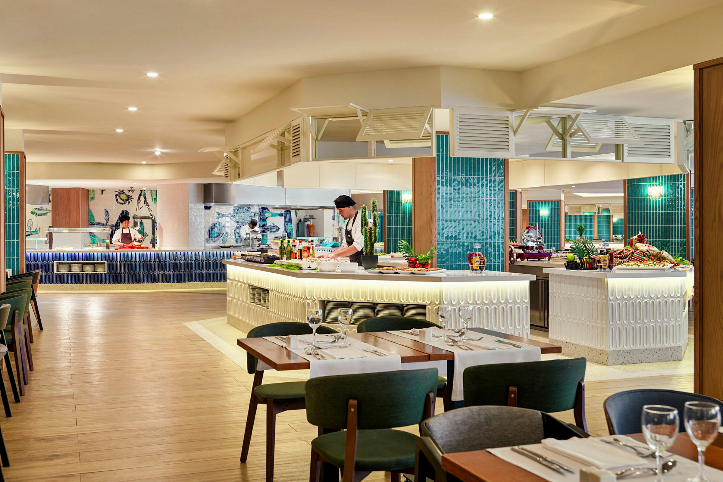En interiörbild som visar en restaurang med sittplatser och öppet kök där personal arbetar. (AI-genererad text)