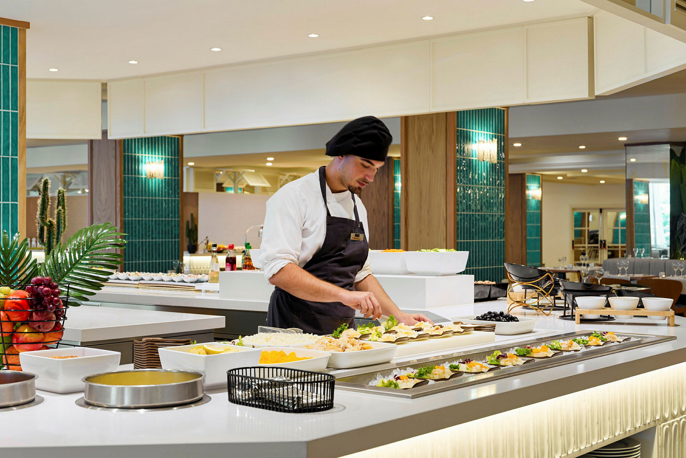 En kock i ett kök arrangerar mat på ett buffébord. (AI-genererad text)