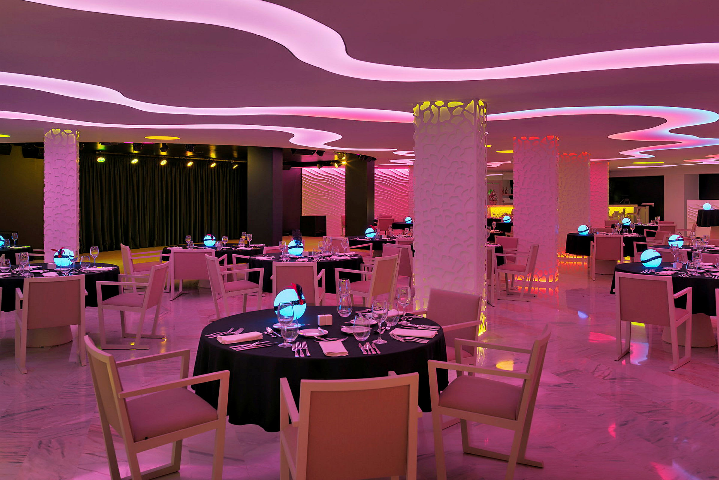 Restaurang med moderna möbler och färgade ljussättning. (AI-genererad text)