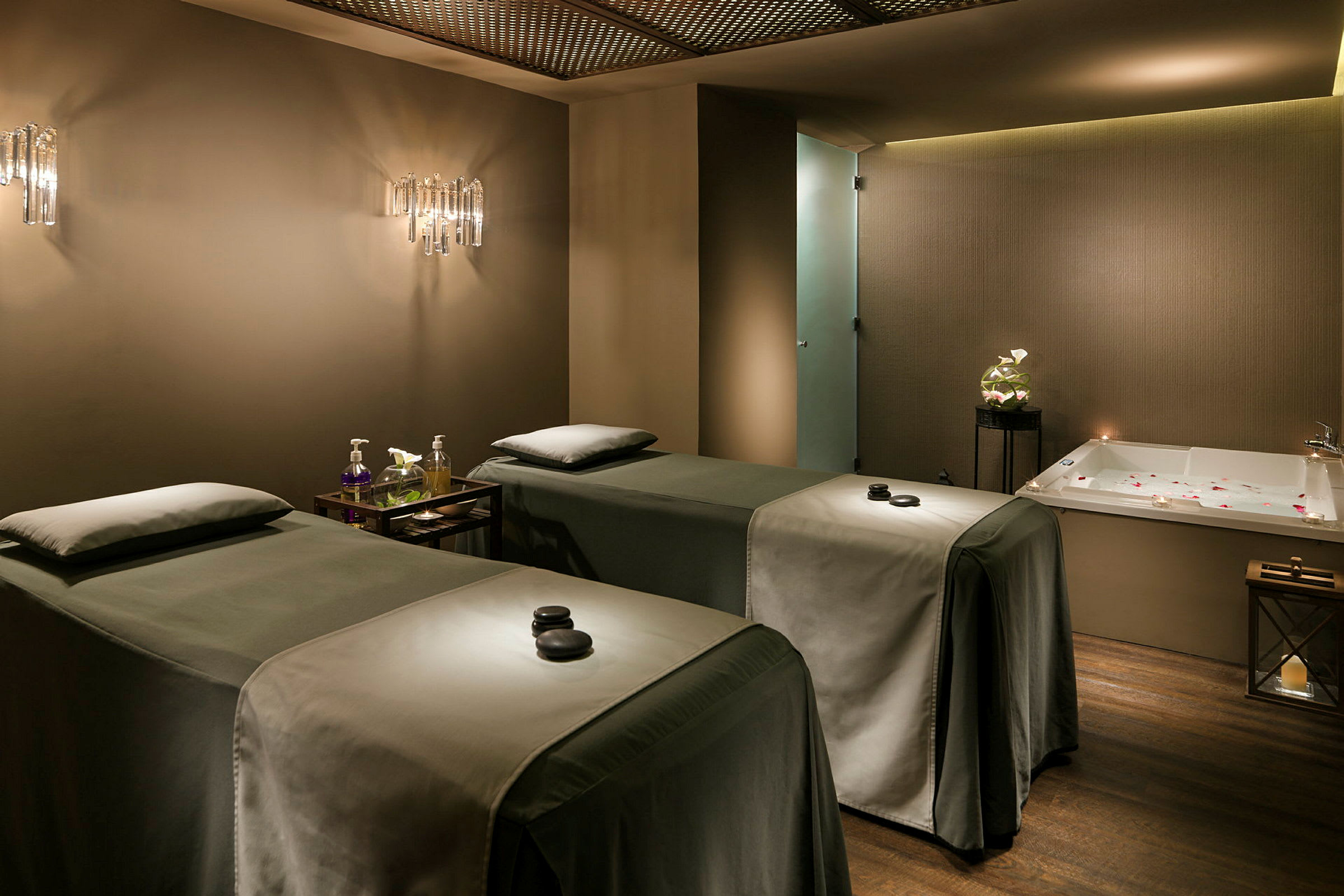 En spa-behandlingsrum med två behandlingssängar och ett badkar. (AI-genererad text)