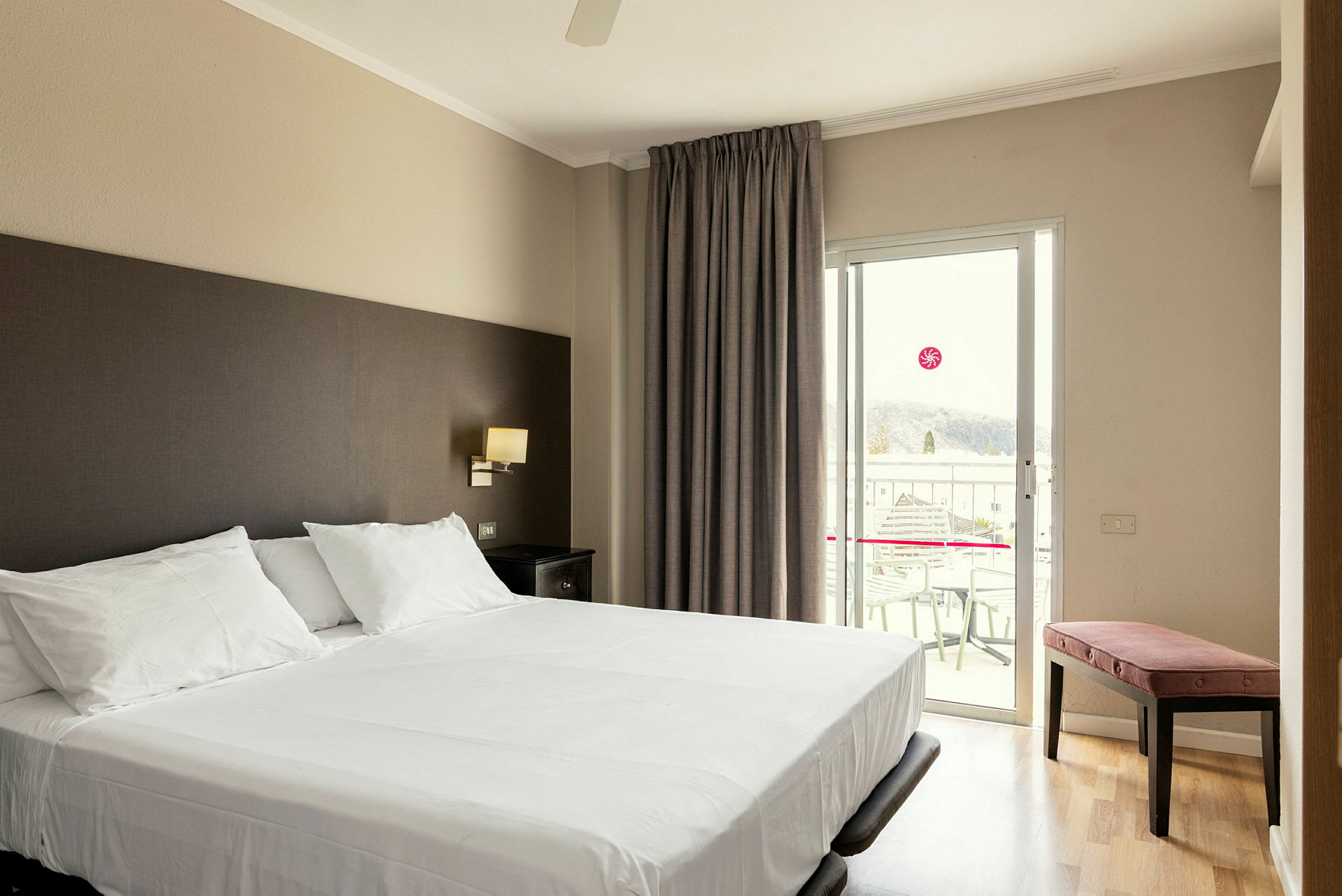 Hotellrum med en dubbelsäng och balkong. (AI-genererad text)