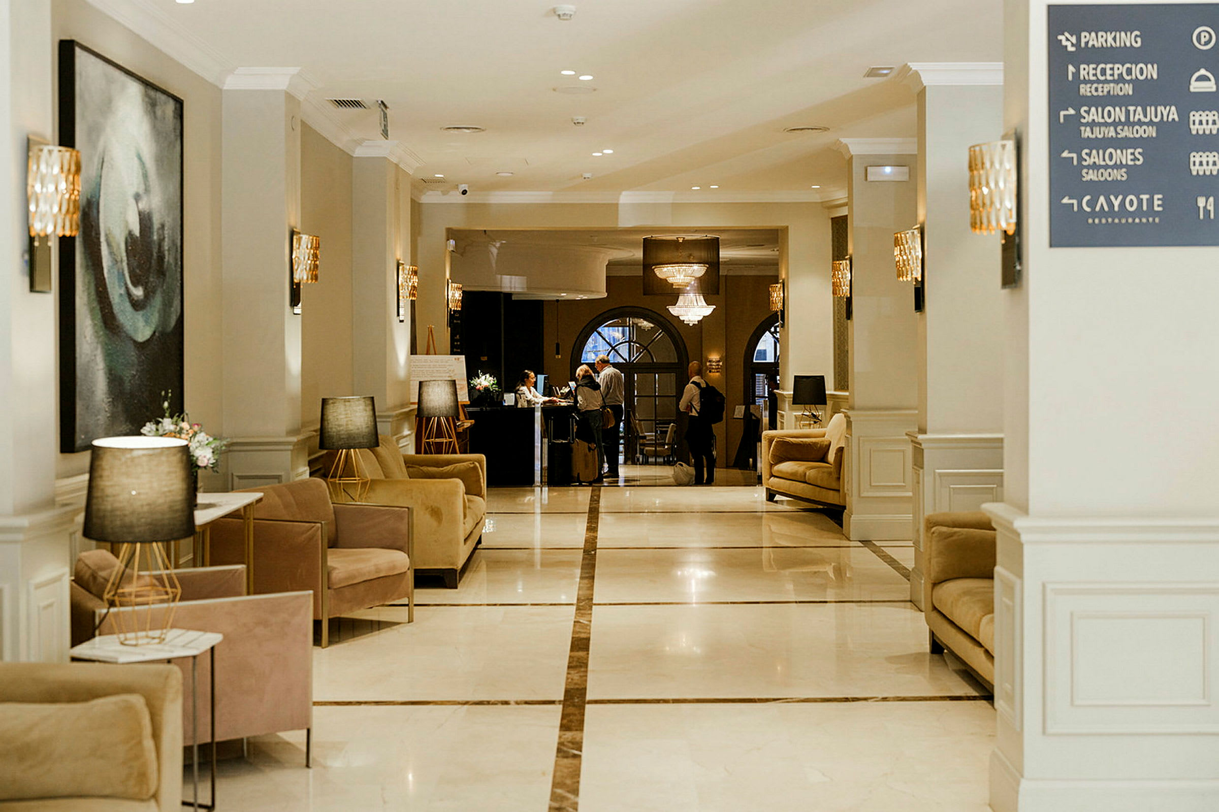 Bilden visar en hotellobby med eleganta sittmöbler och en reception i bakgrunden. (AI-genererad text)
