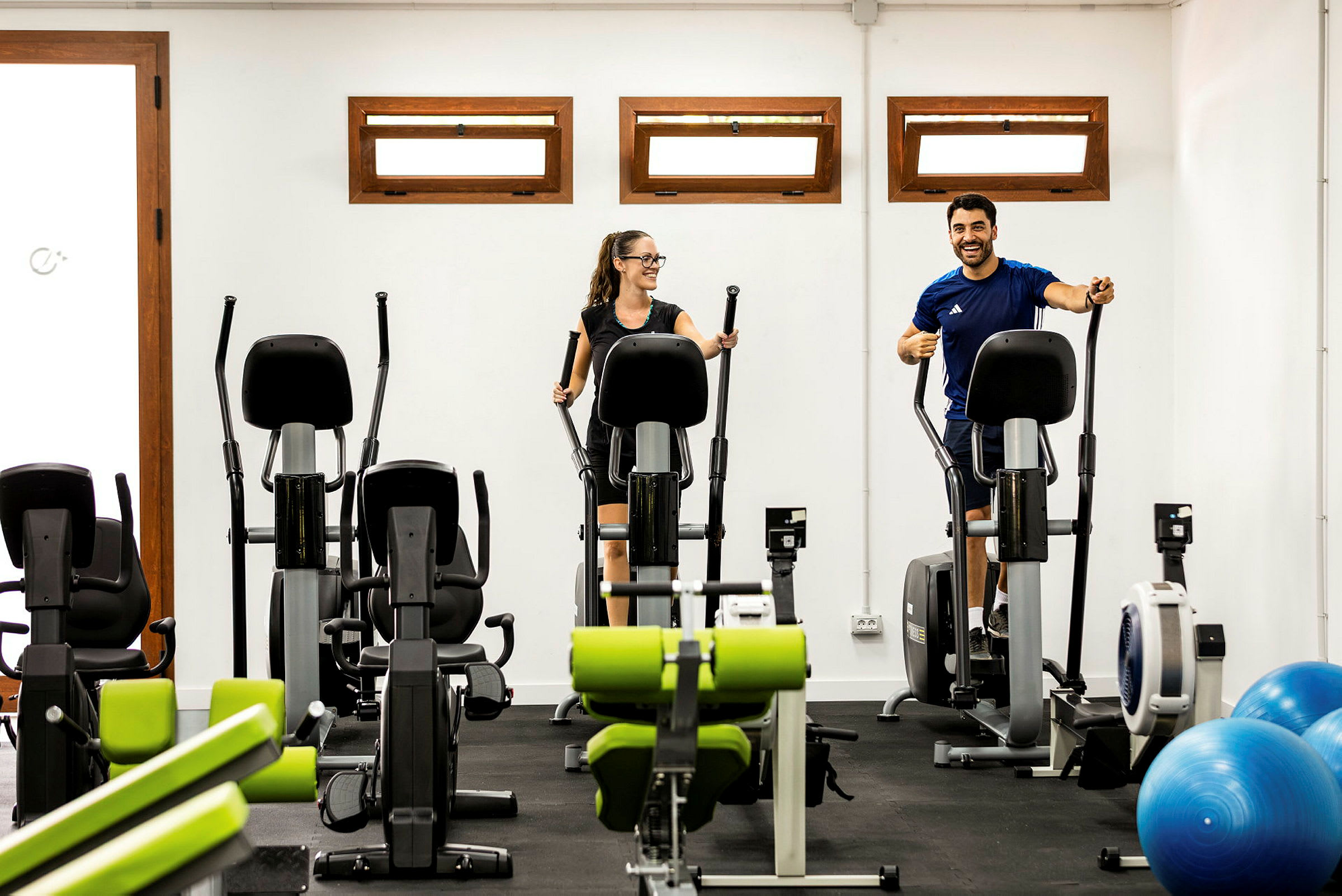 Två personer som använder träningsmaskiner i ett gym. (AI-genererad text)