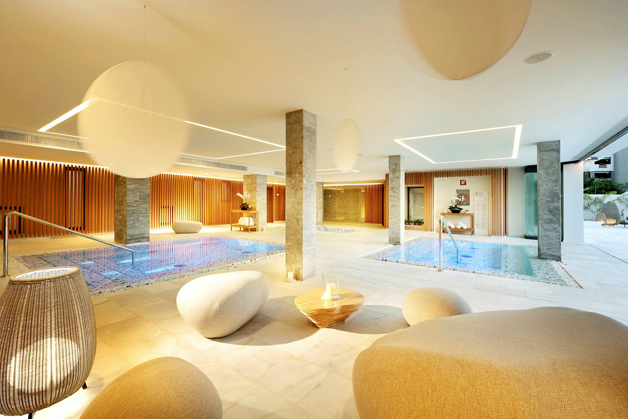 Ett modernt spa med inomhuspooler, sittplatser och elegant belysning. (AI-genererad text)
