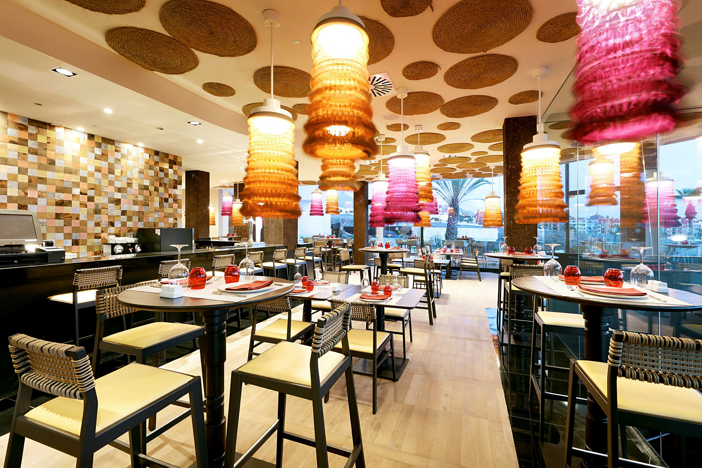 Modern restaurang med dekorativa taklampor och dukade bord. (AI-genererad text)