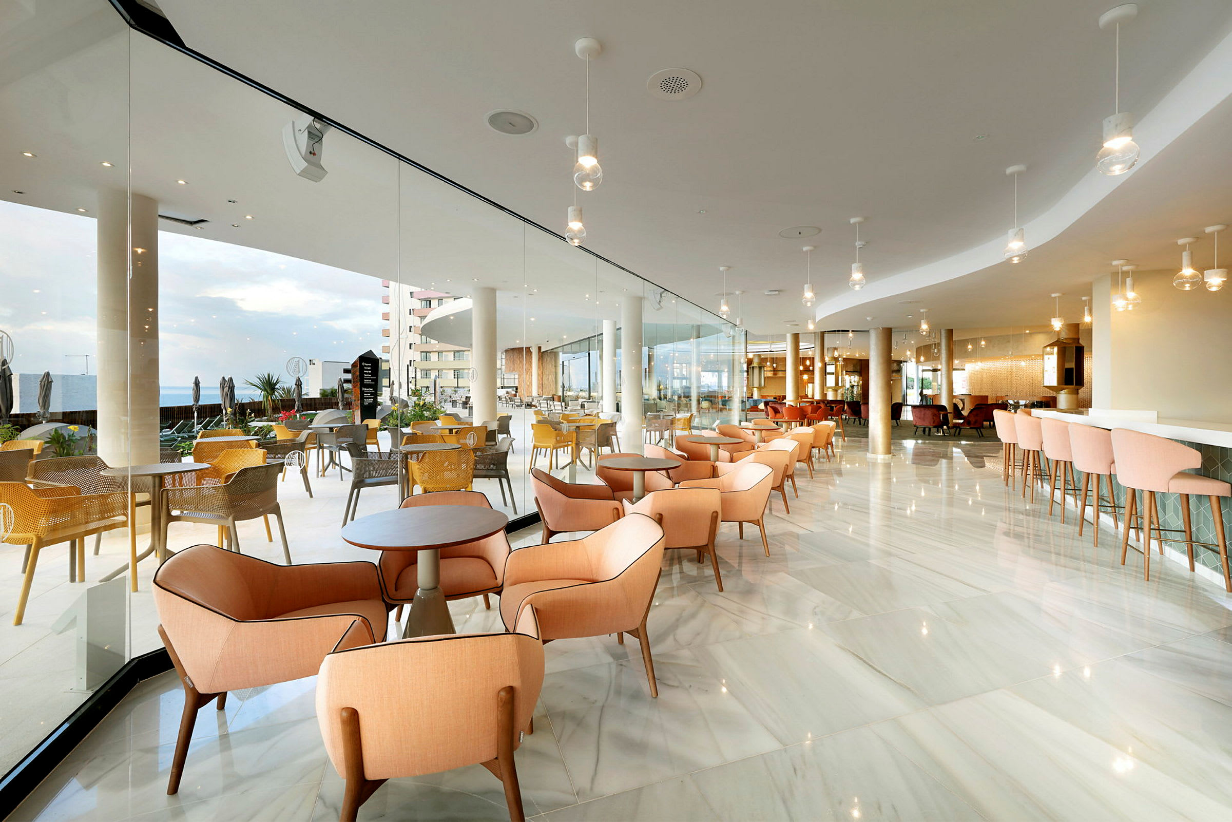 Modern restaurangmiljö med ljusa möbler och glasväggar. (AI-genererad text)