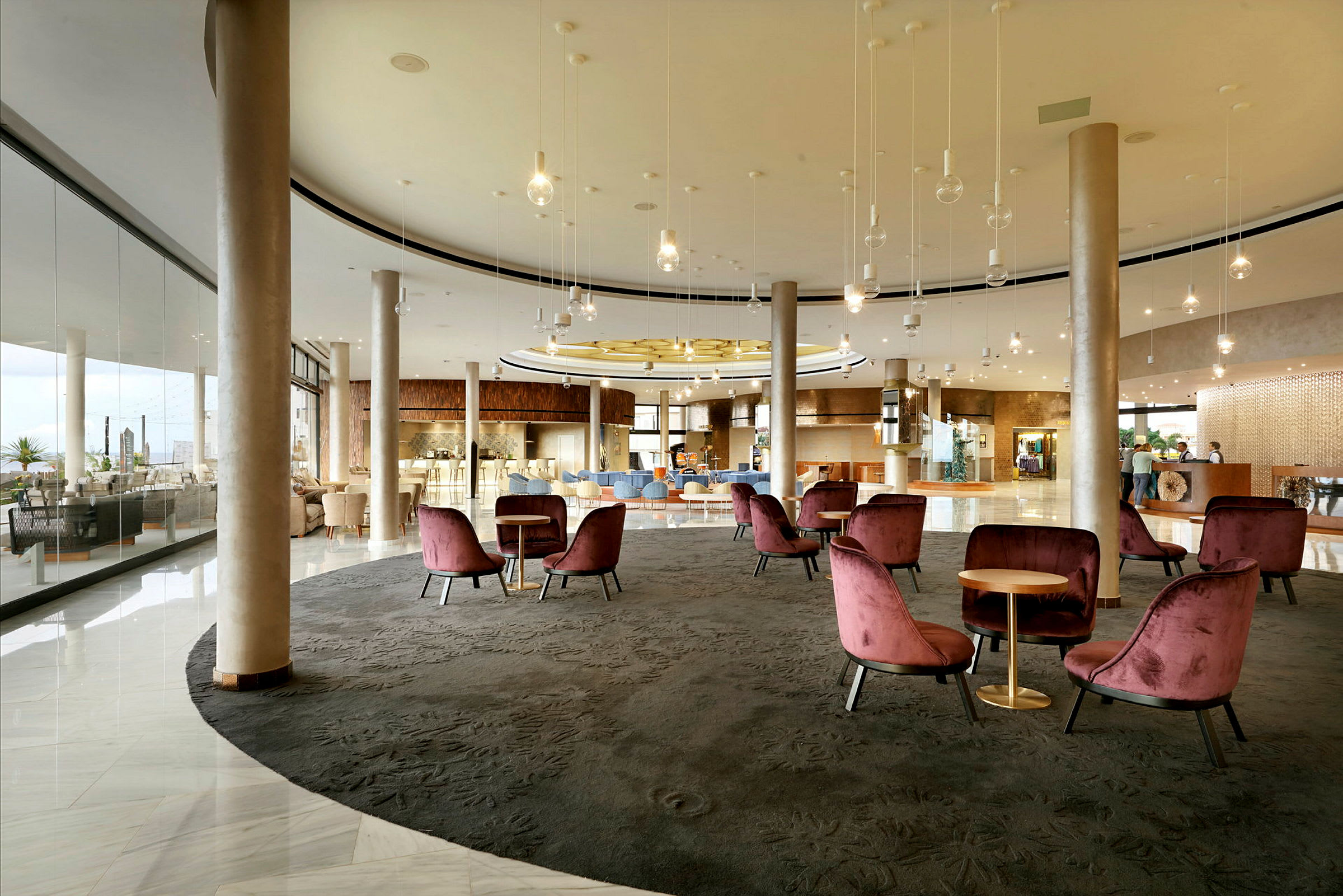En hotellobby med soffgrupper och bord i en rymlig och stilfull miljö. (AI-genererad text)