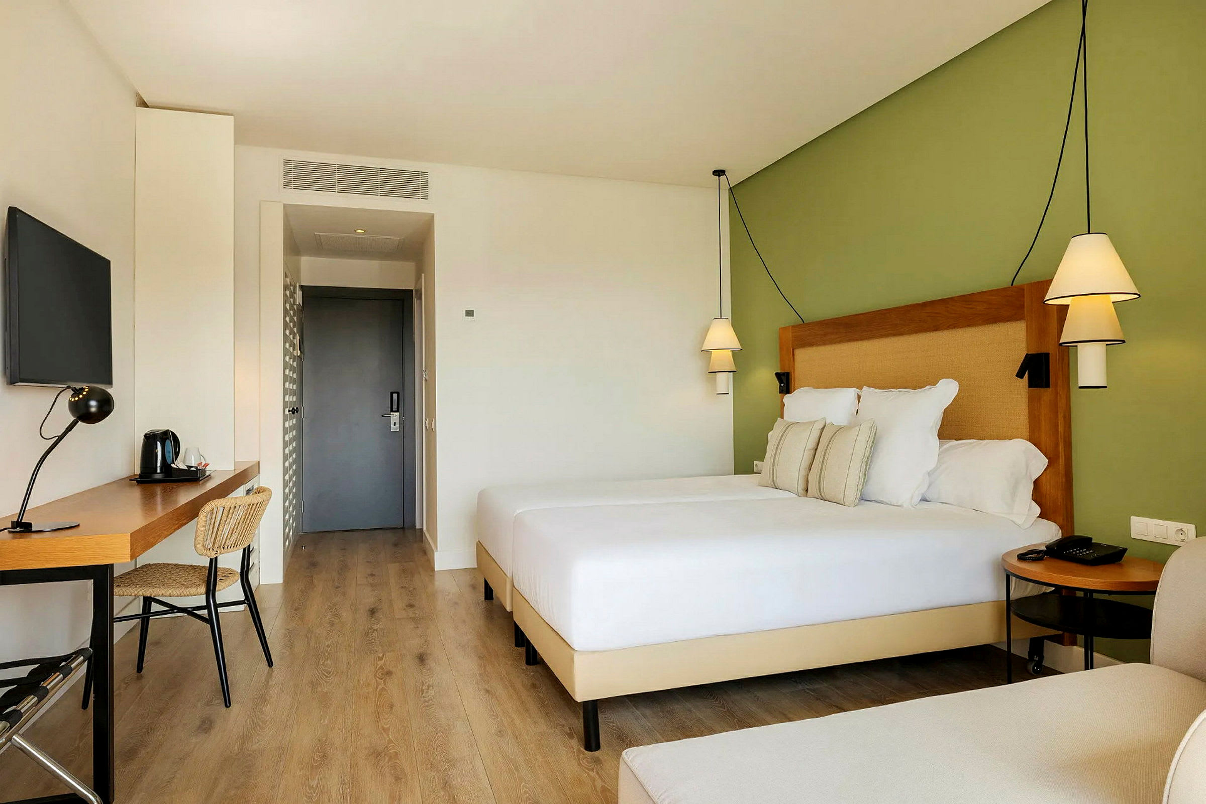 Modernt hotellrum med en dubbelsäng, skrivbord och stol. (AI-genererad text)