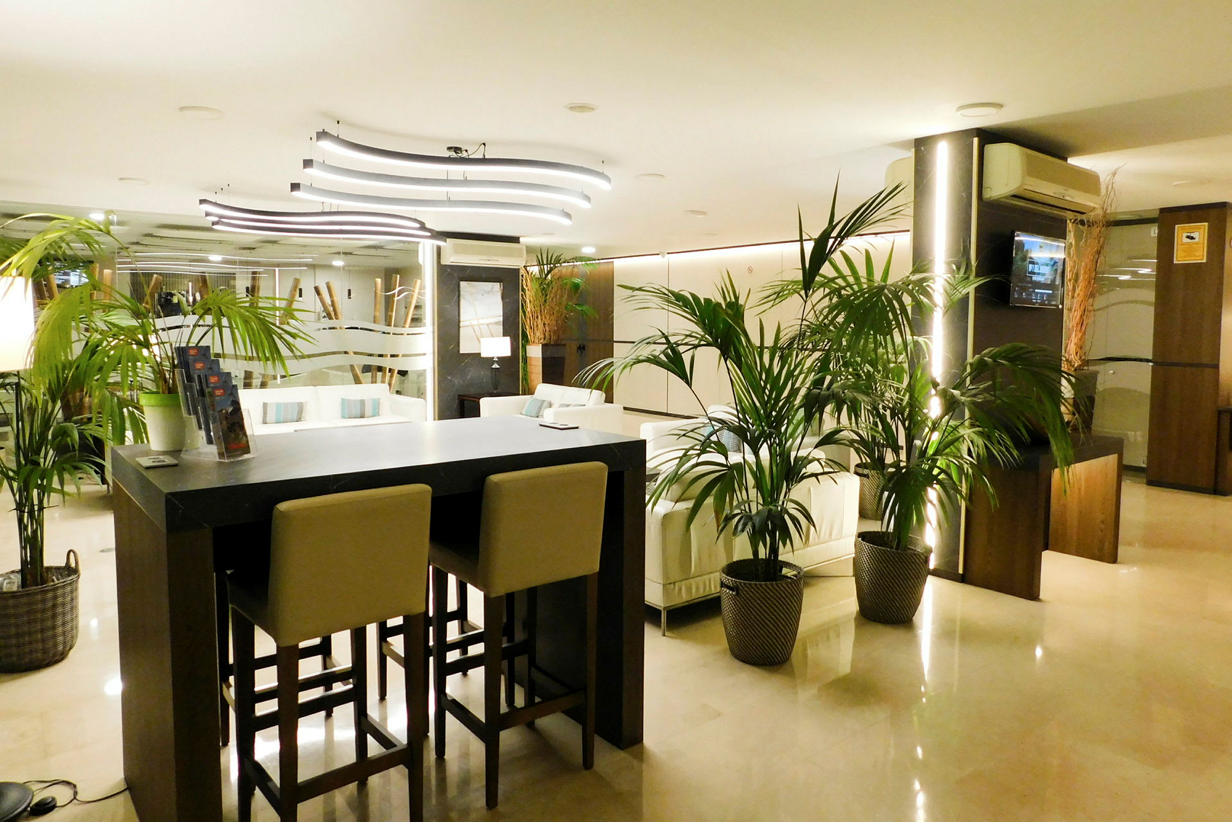 Hotellets lobby med modern inredning, soffor och växter. (AI-genererad text)