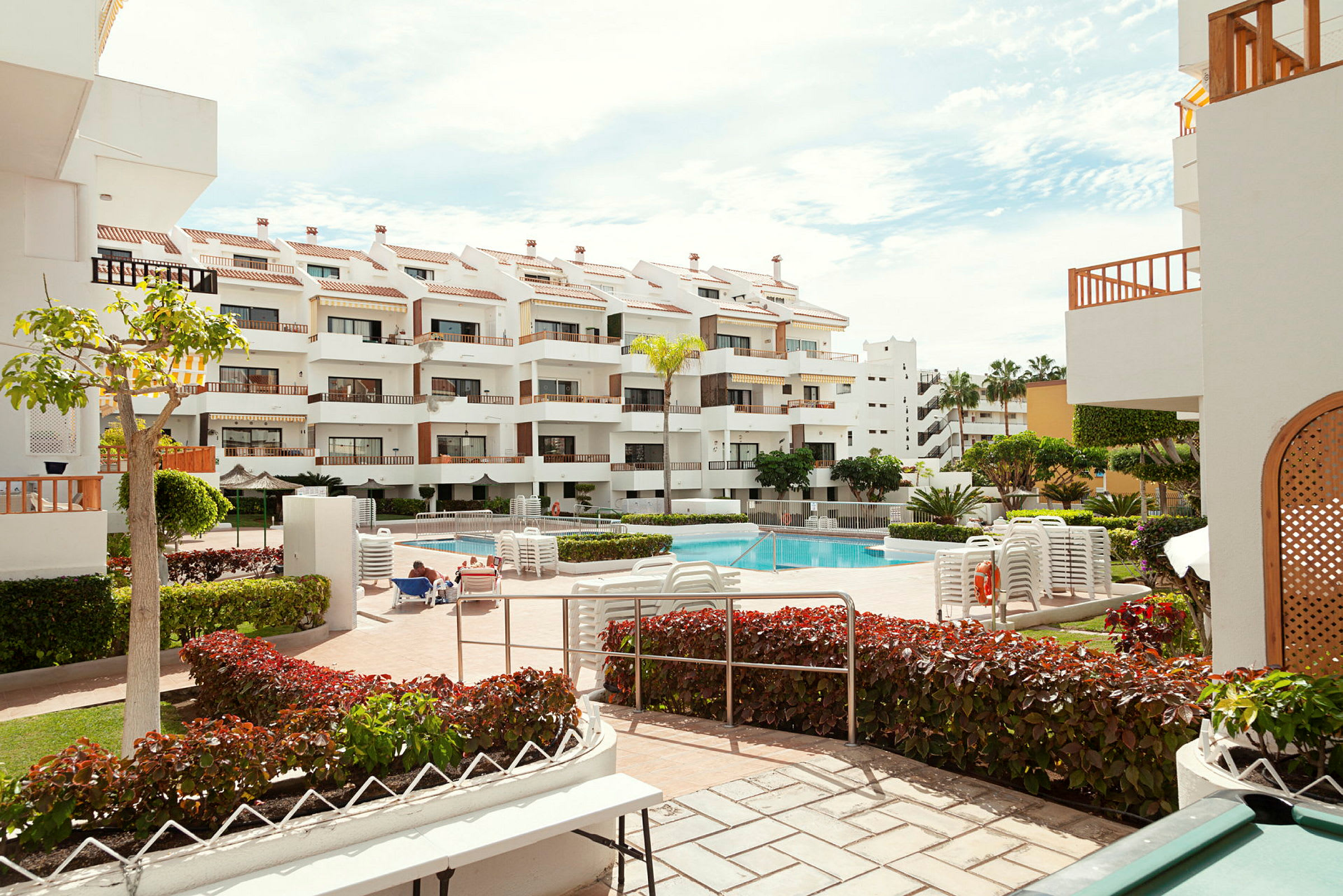 Bild av en hotellbyggnad med balkonger och en pool i föremålet. (AI-genererad text)