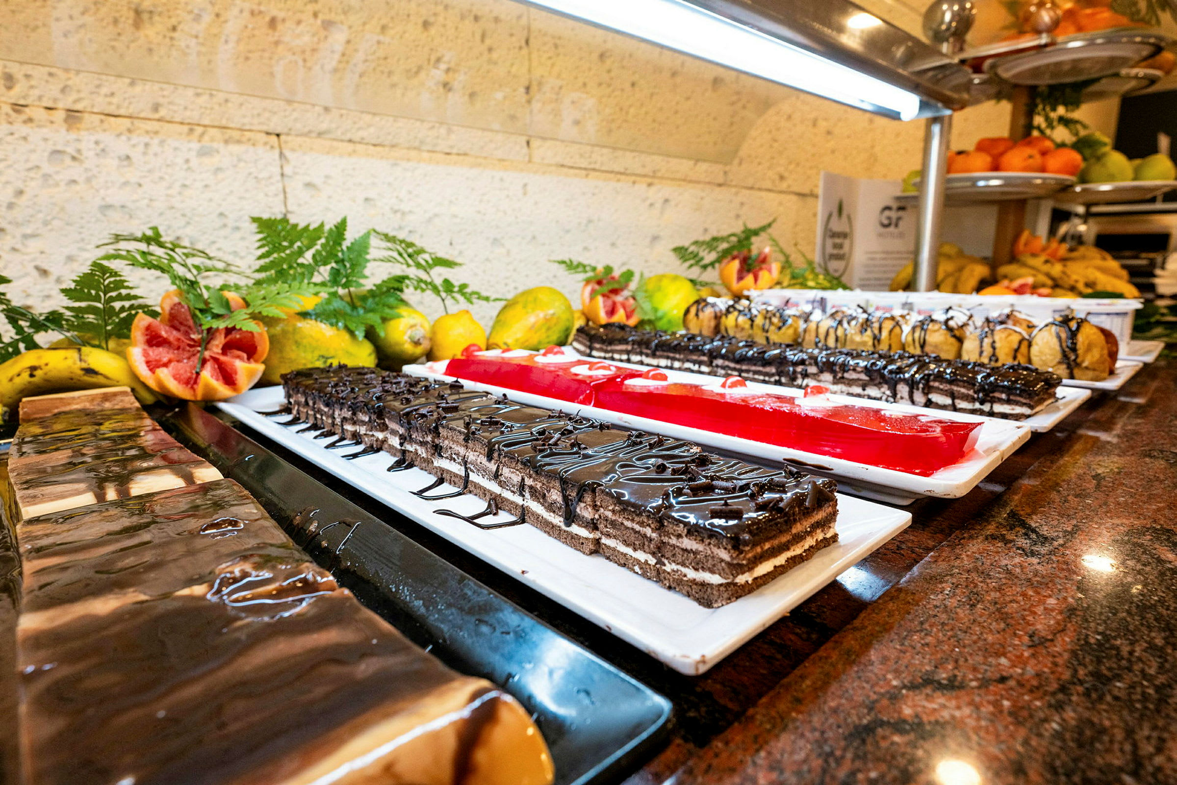 Buffébord med olika desserter, inklusive frukt och bakverk. (AI-genererad text)