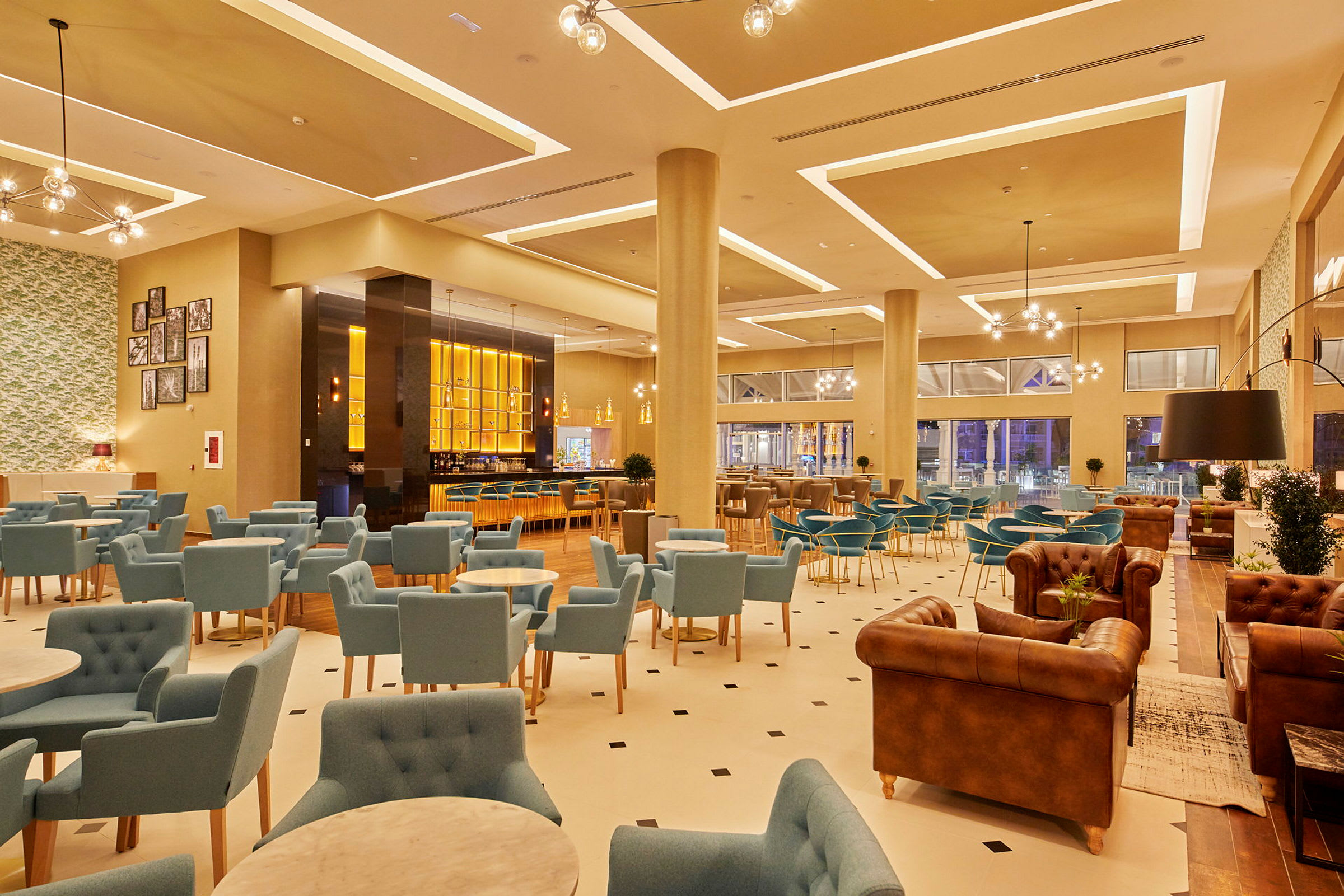Ett modernt hotellområde med sittgrupper och en uppljup bar. (AI-genererad text)